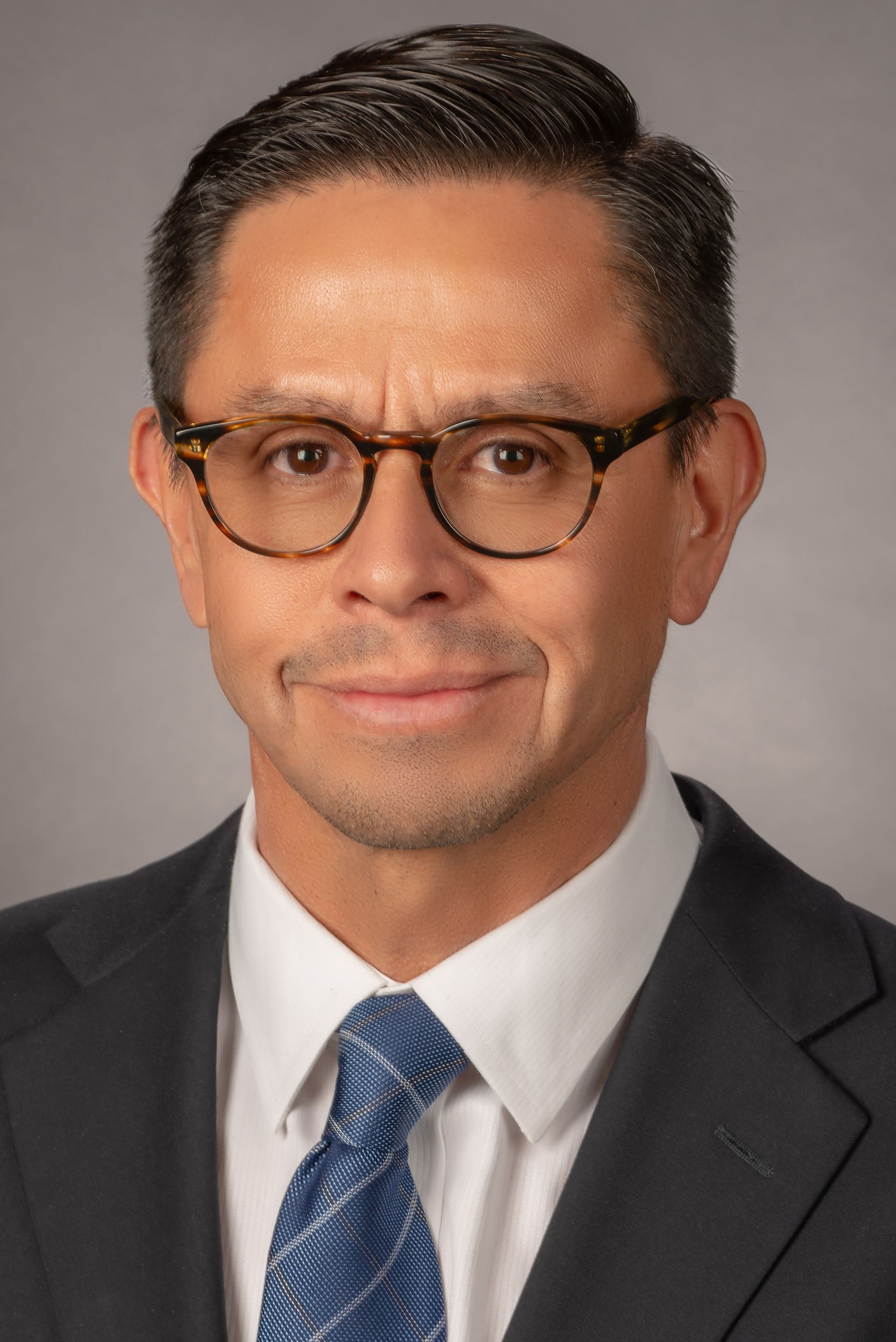 A man in a suit and tie is wearing glasses.