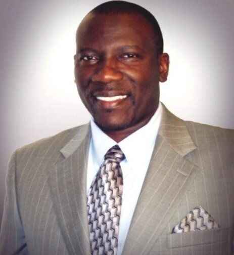 A man in a suit and tie smiles for the camera