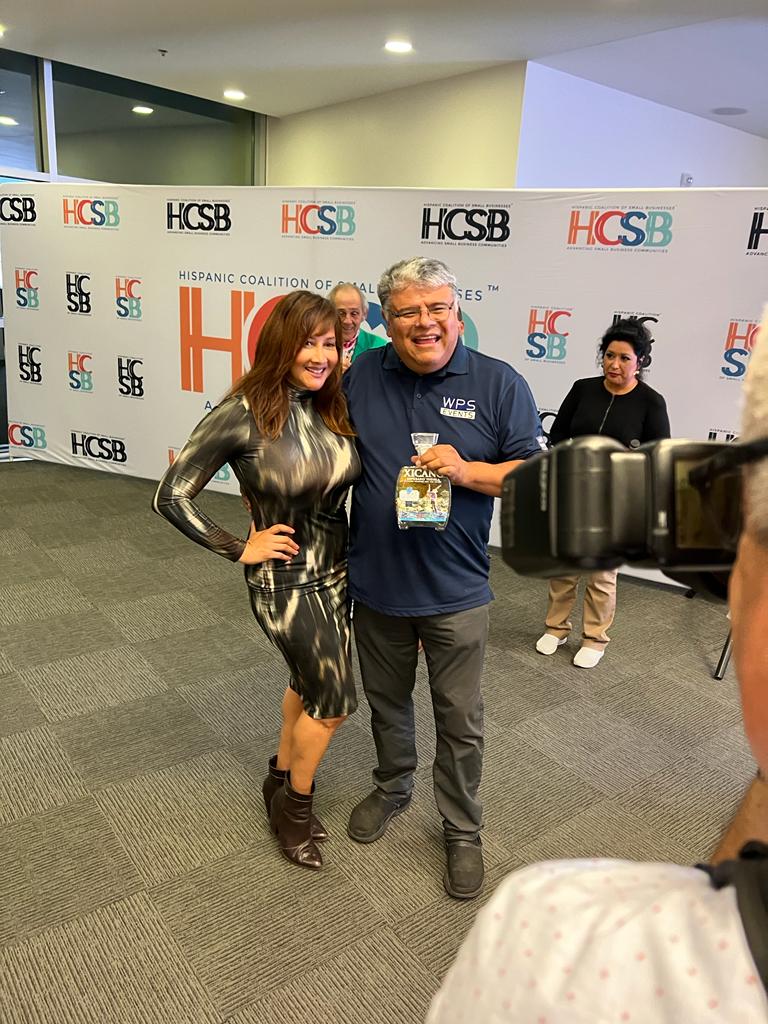 A man and a woman are posing for a picture in front of a camera.