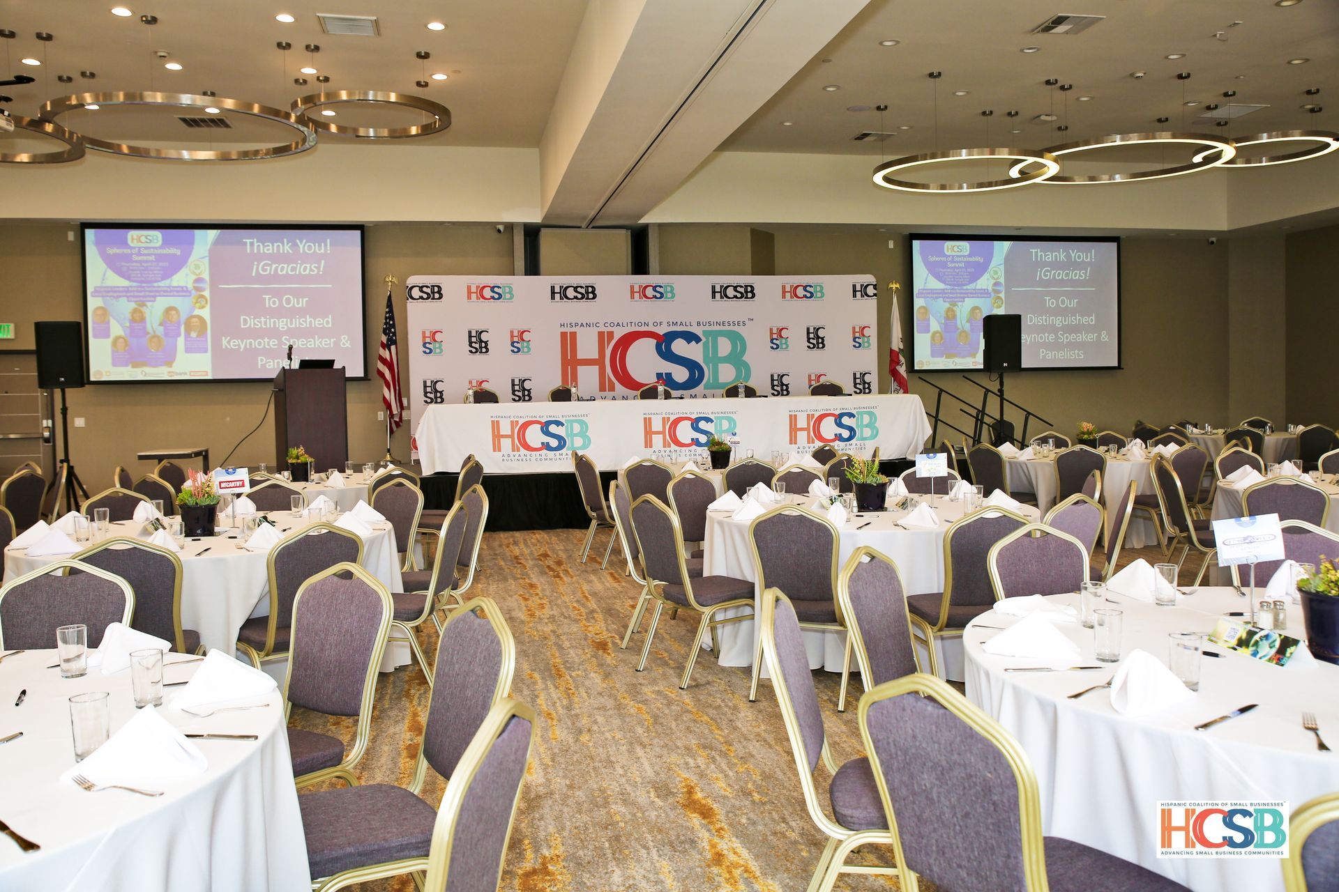 A large room with tables and chairs set up for a hcsb event
