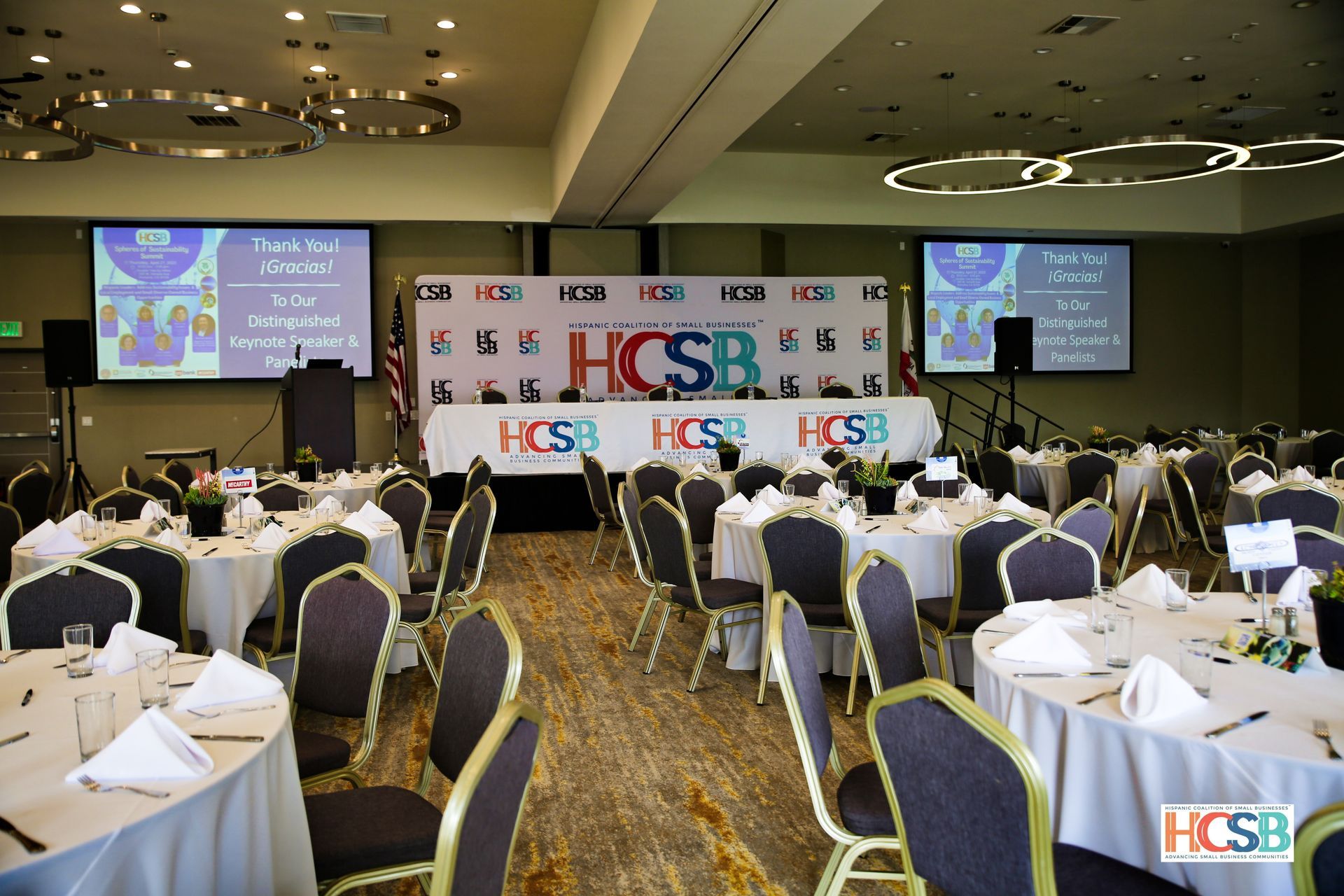 A large room with tables and chairs set up for a hcsb event