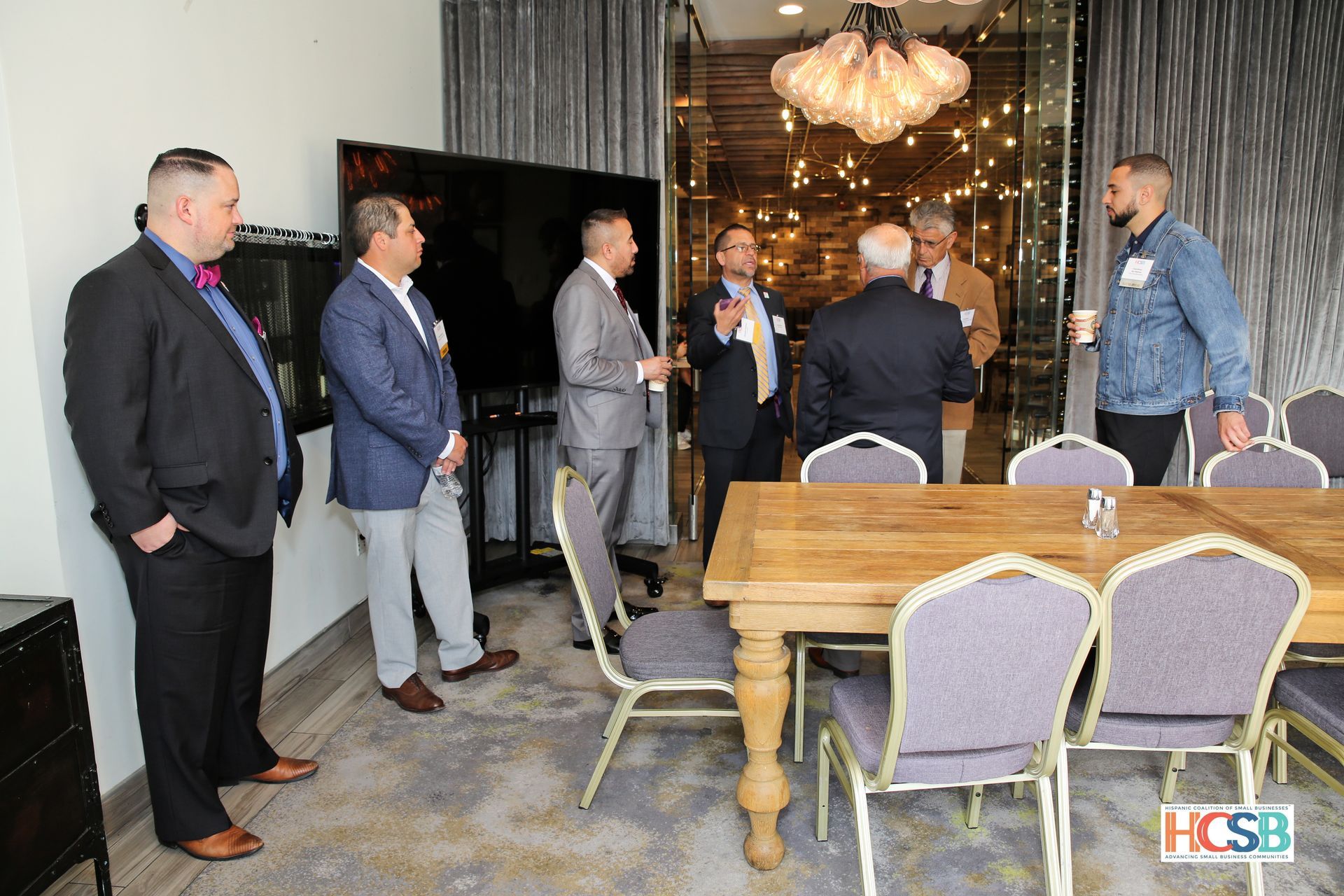 A group of men are standing around a table in a room.