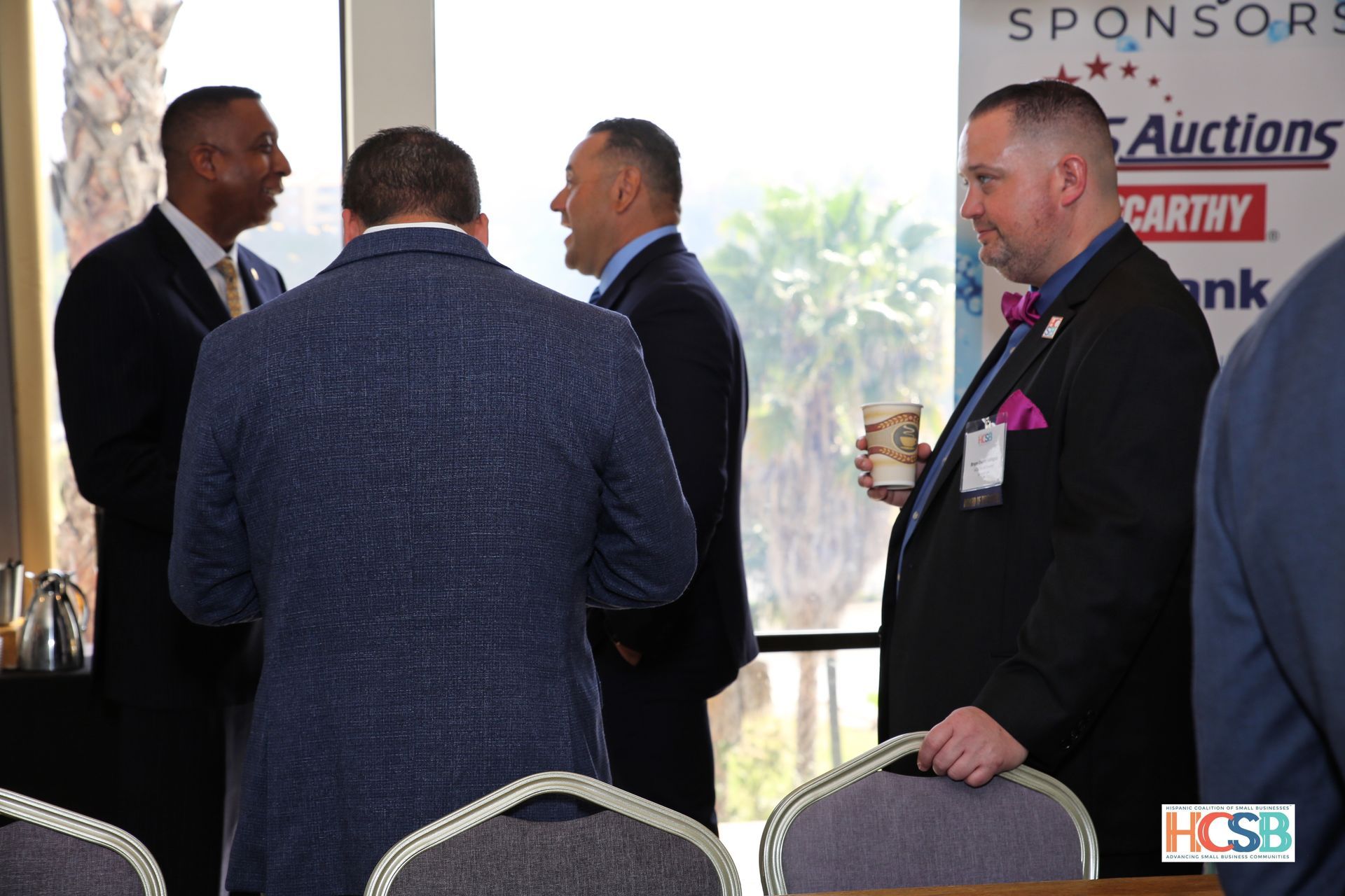 A group of men standing in front of a sign that says sponsors