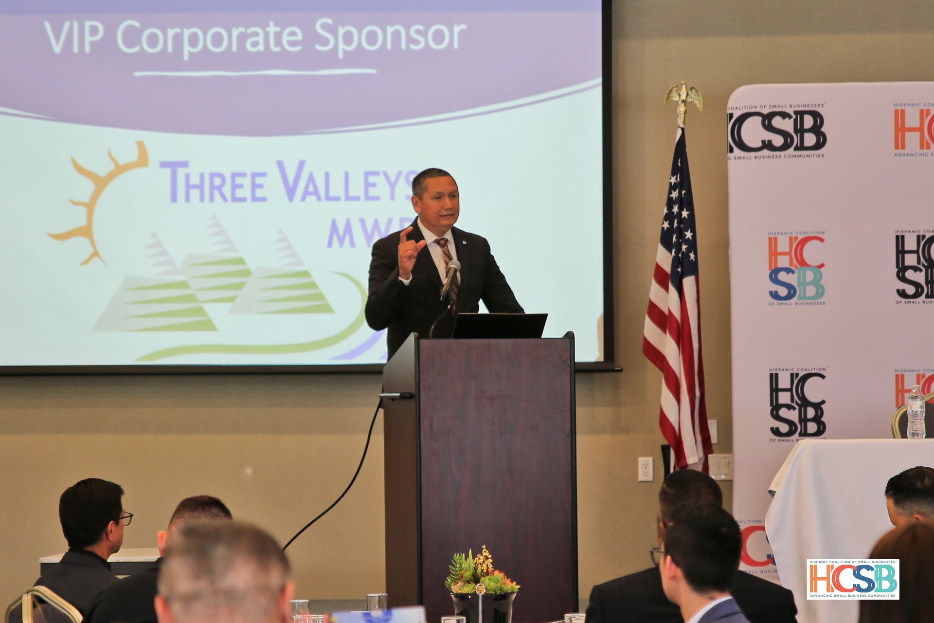 A man is standing at a podium giving a presentation to a group of people.