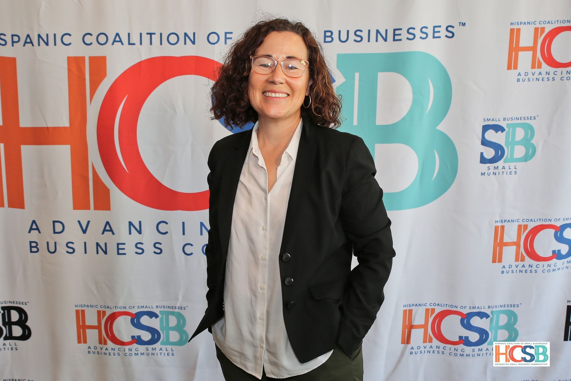 A woman is standing in front of a hcsb banner.