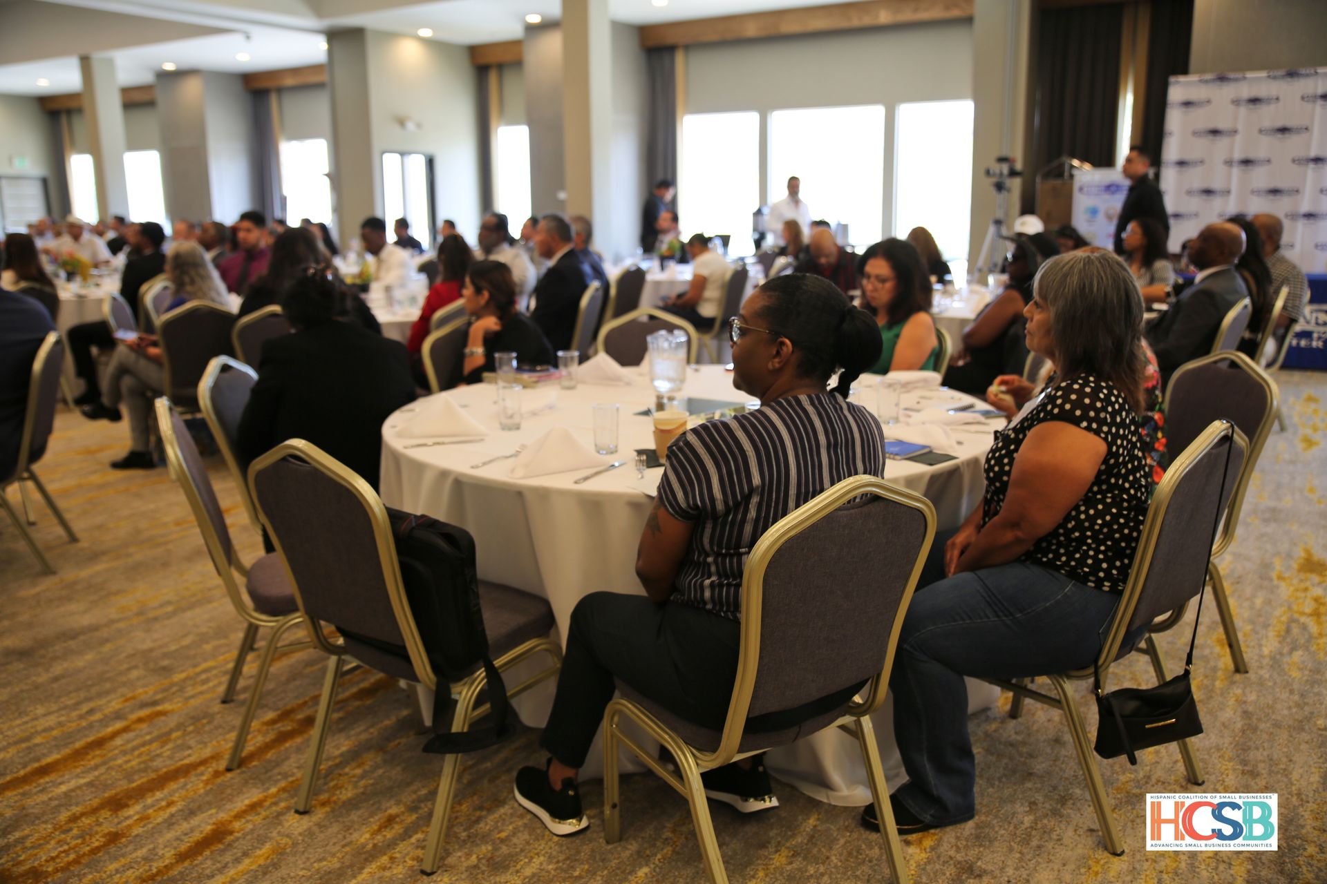 A group of people are sitting at tables in a room.