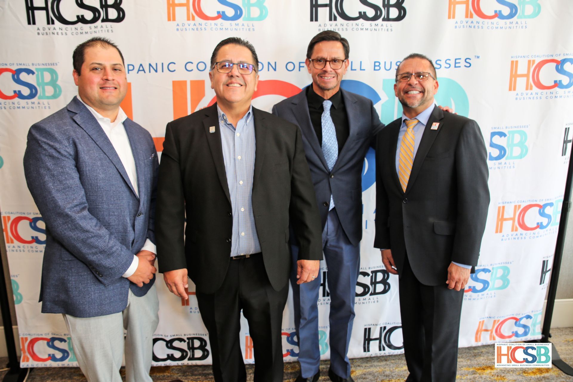 A group of men in suits and ties are posing for a picture.