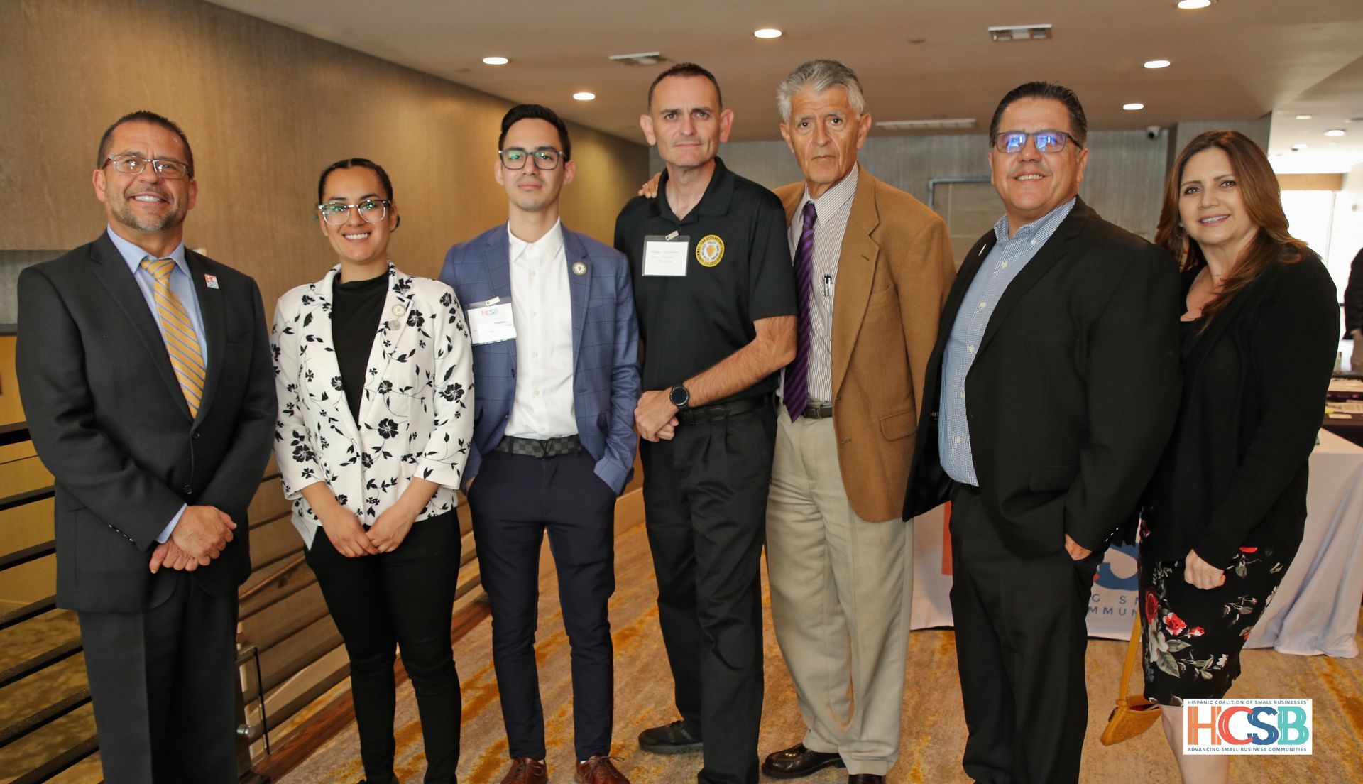 A group of people in suits and ties are posing for a picture.