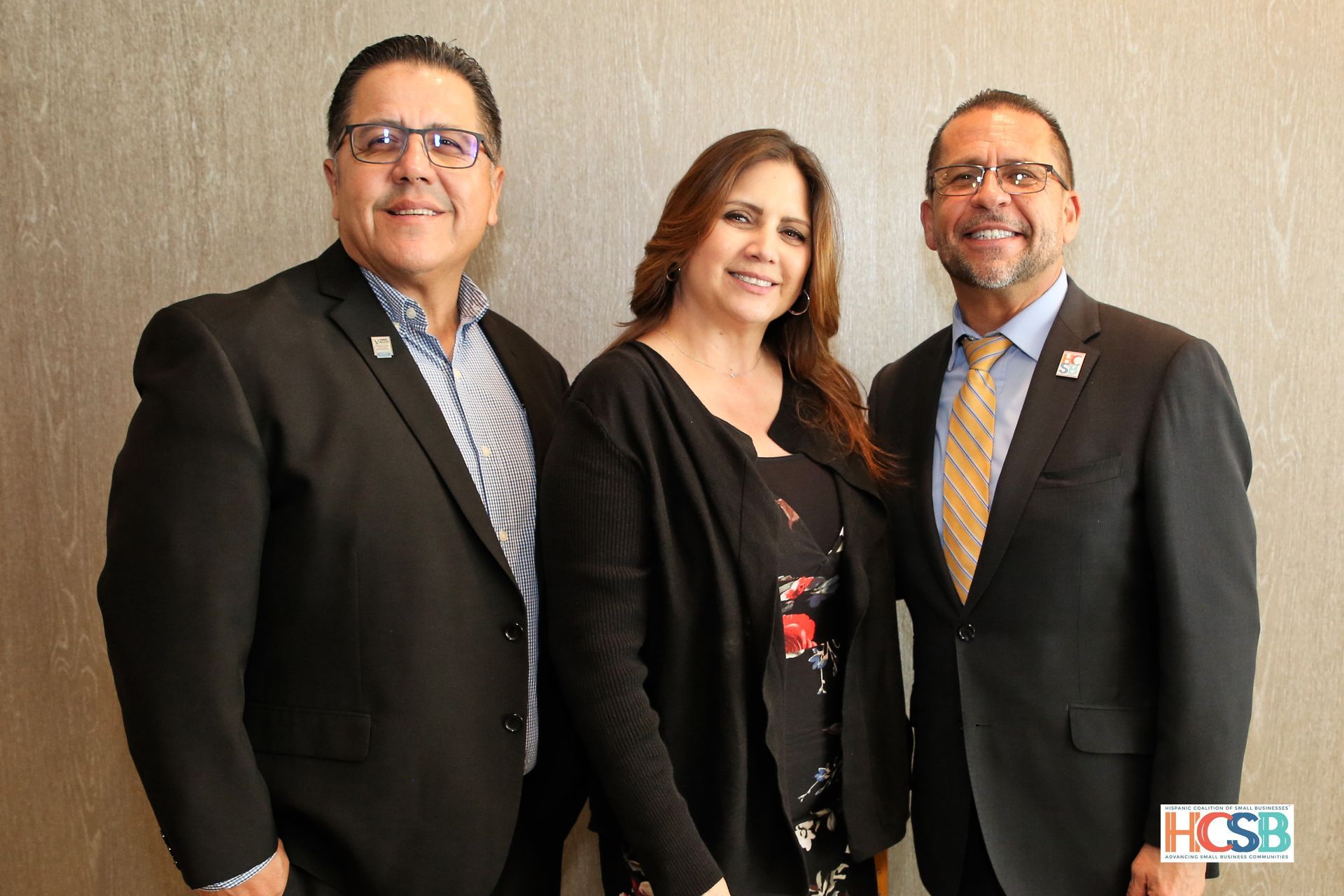 Three people in suits and ties are posing for a picture.