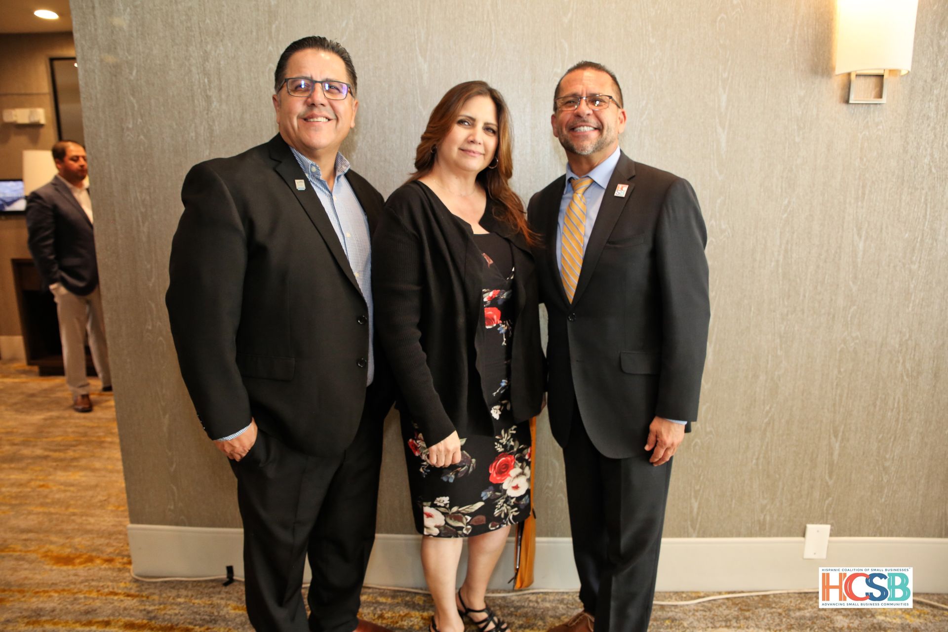 Three people in suits and ties are posing for a picture.