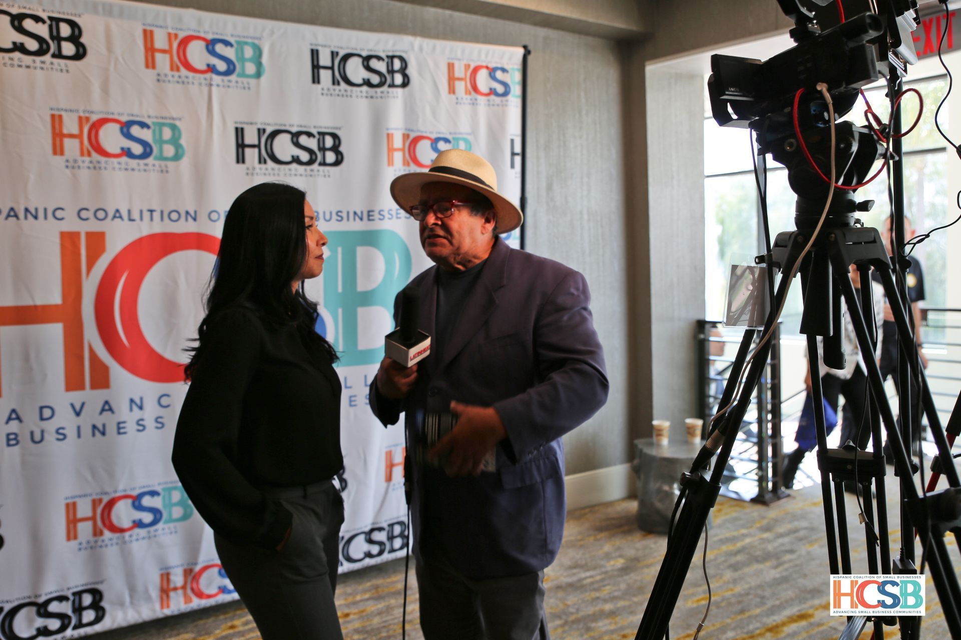 A man and a woman are talking to each other in front of a camera.