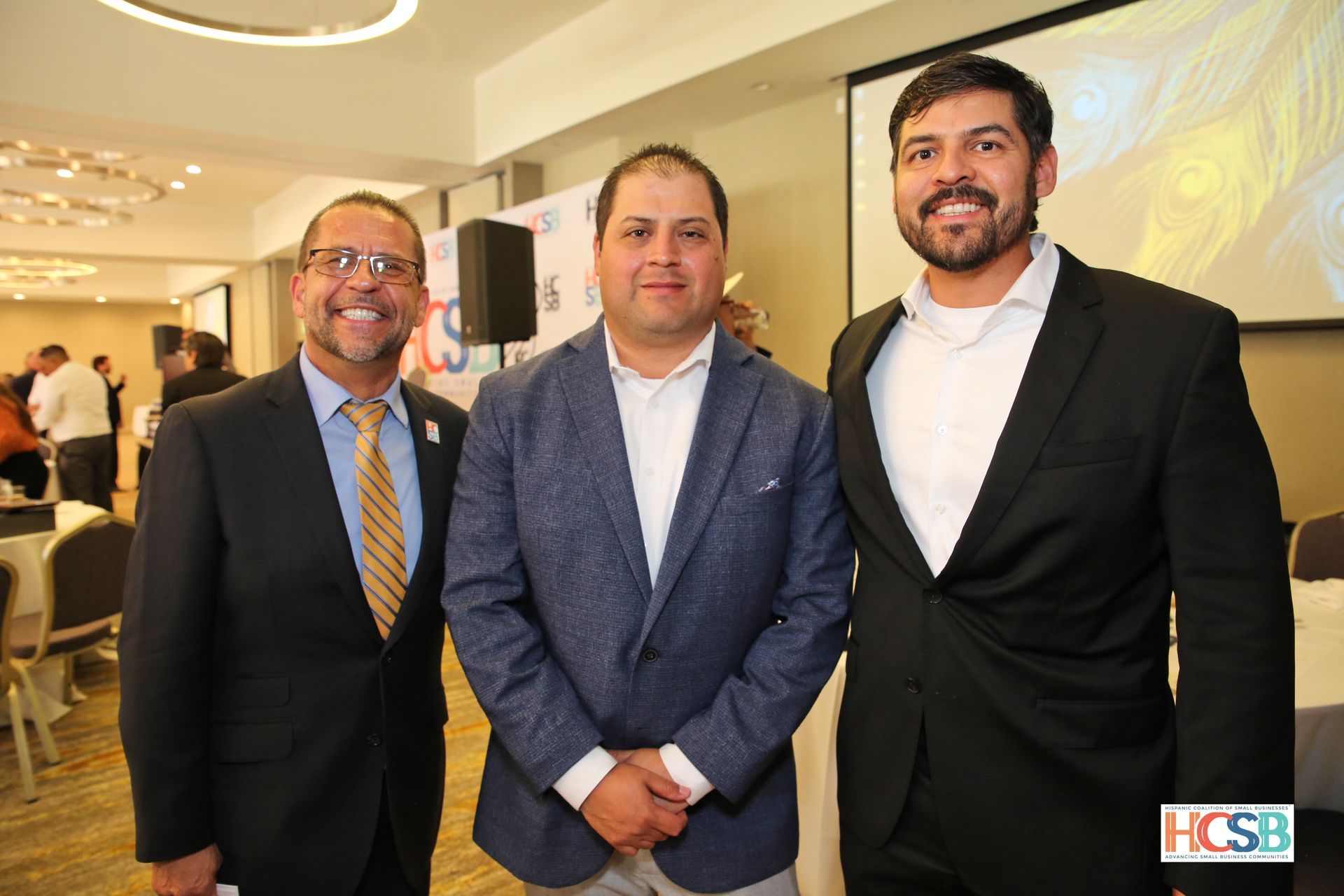 Three men in suits and ties are posing for a picture