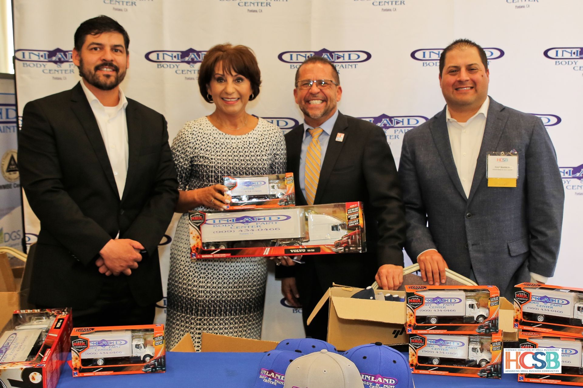 A group of people standing next to each other holding toy trucks