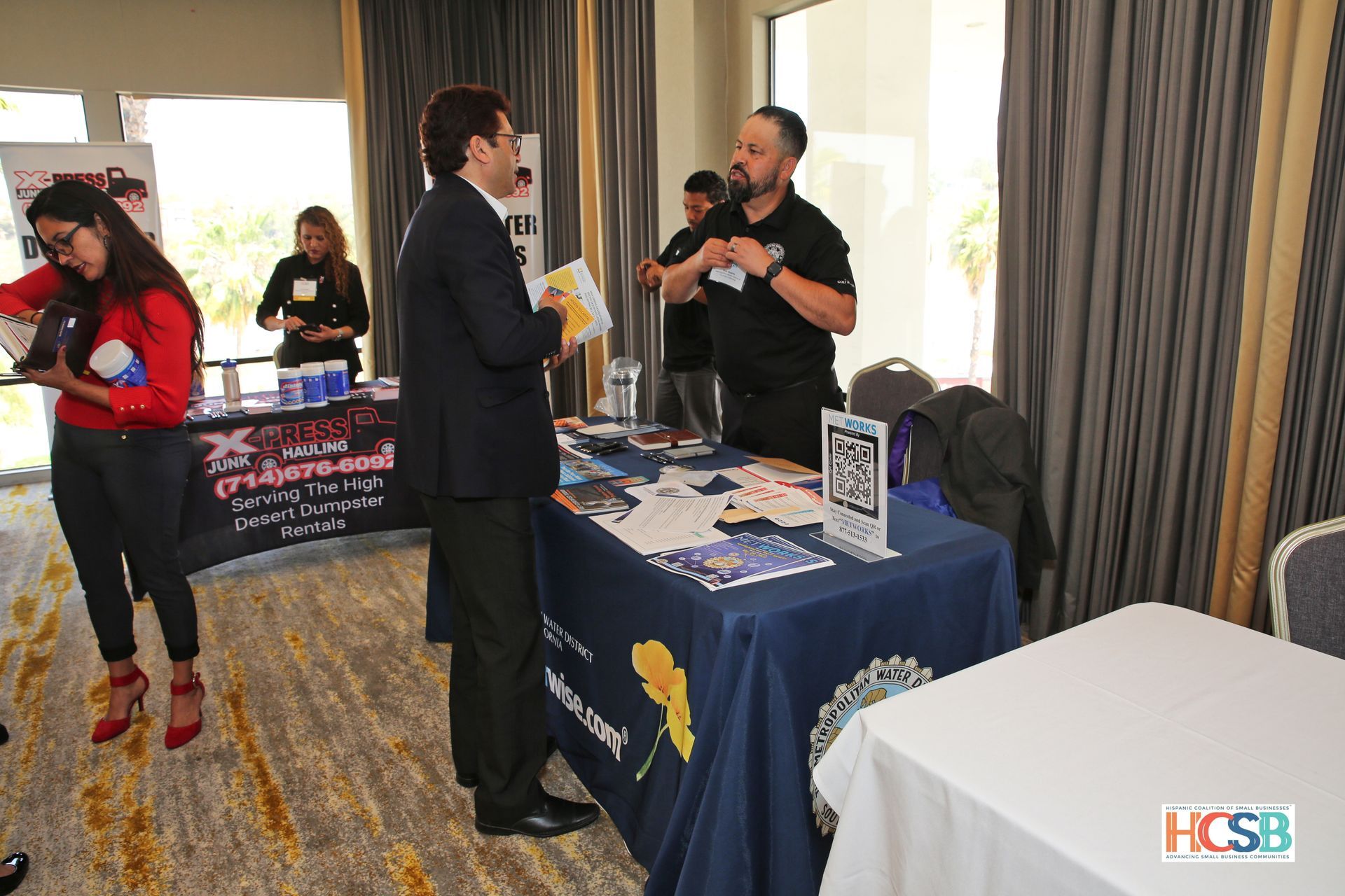 A group of people are standing around a table at a job fair.