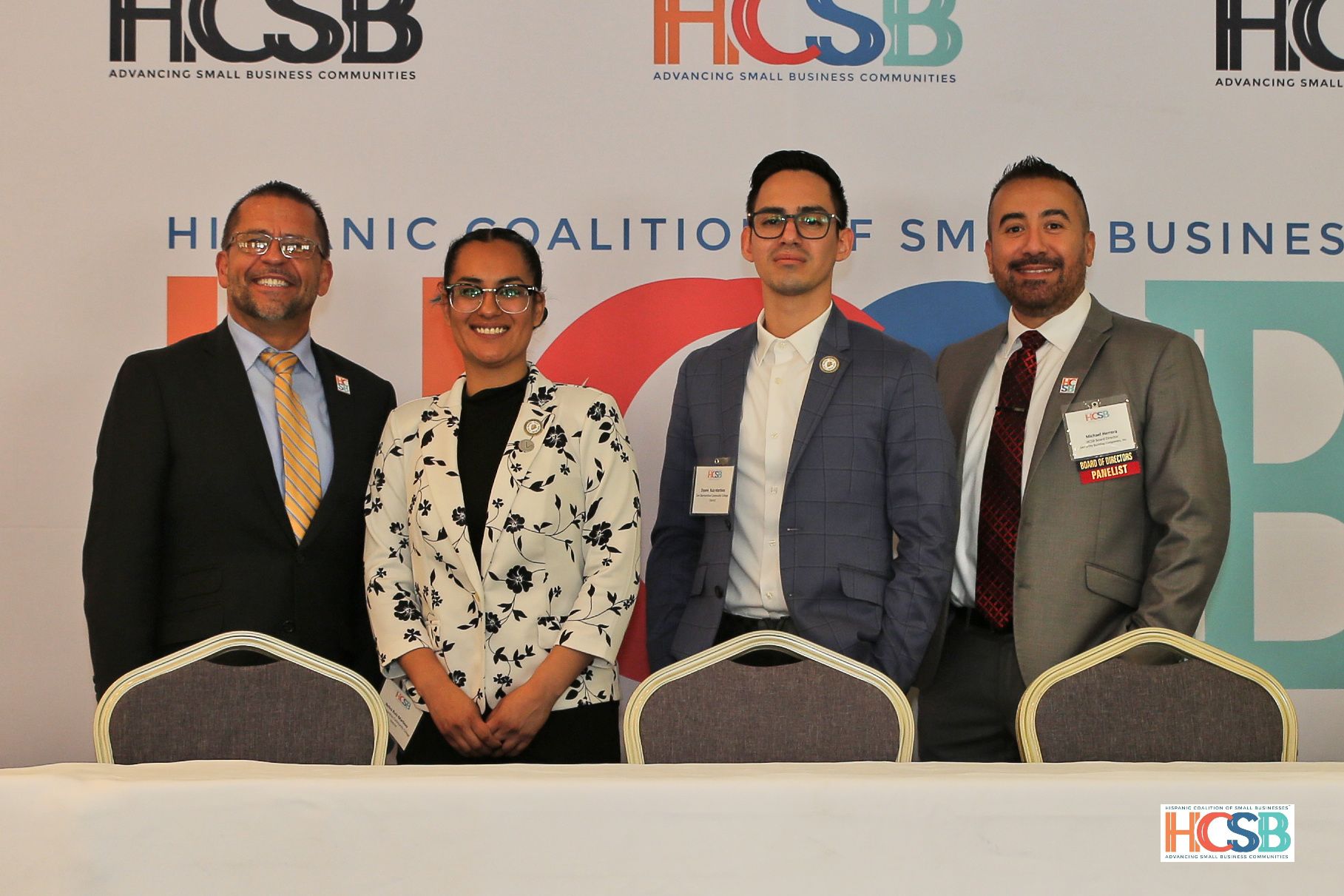 A group of people standing in front of a wall that says hcsb