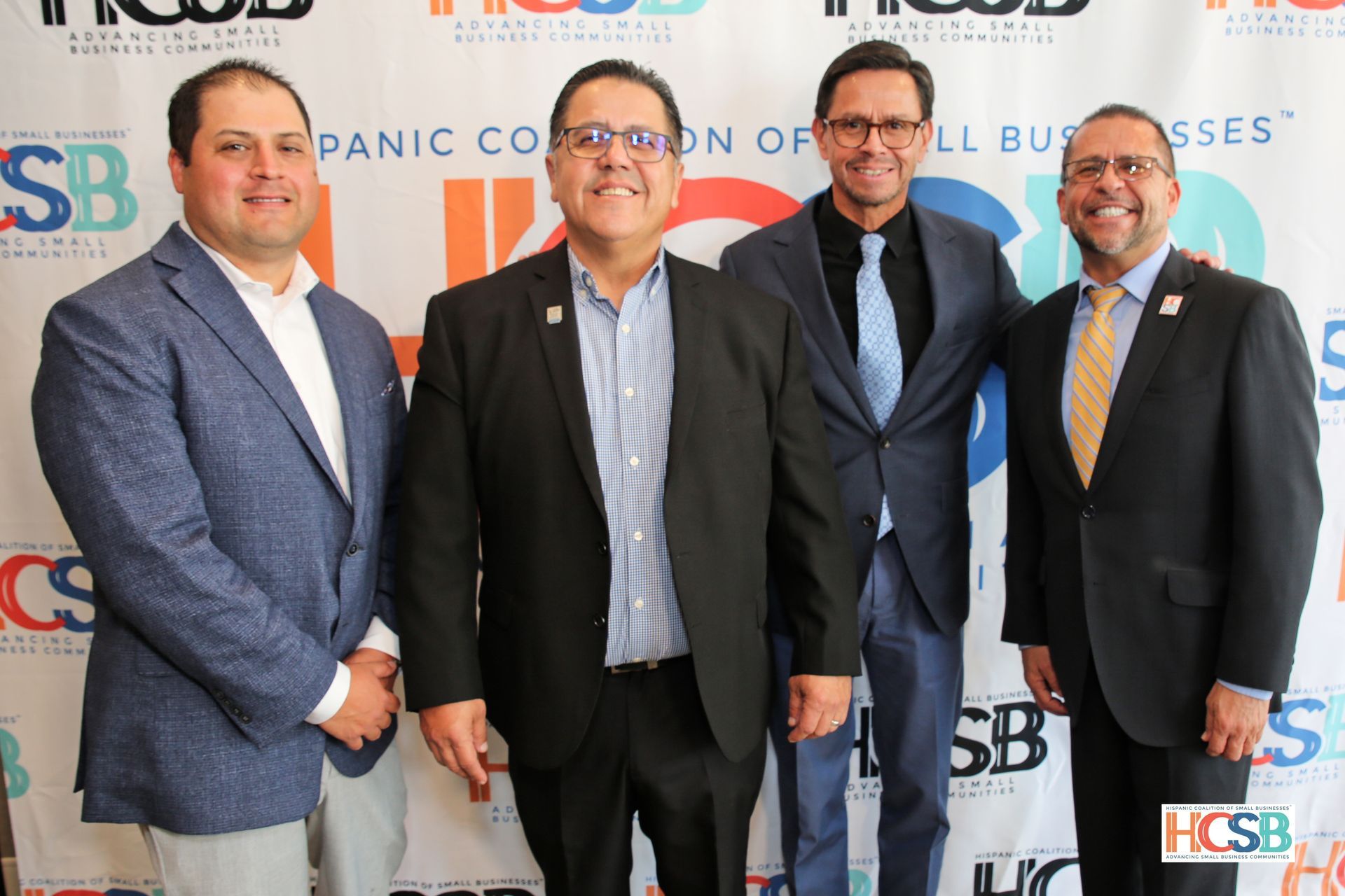 A group of men are posing for a picture in front of a banner that says panic corporation of all business