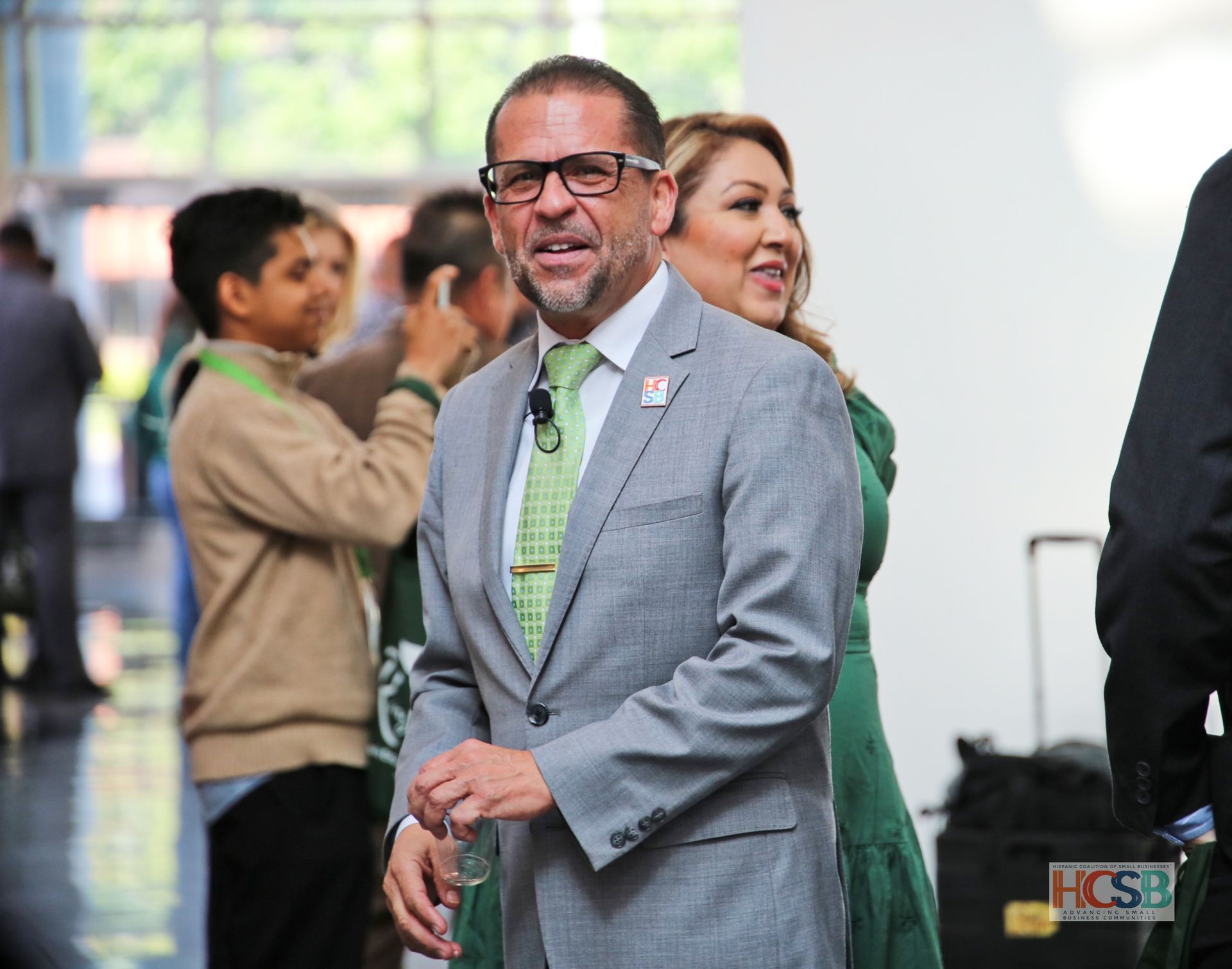 A man in a suit and tie is standing next to a woman in a green dress