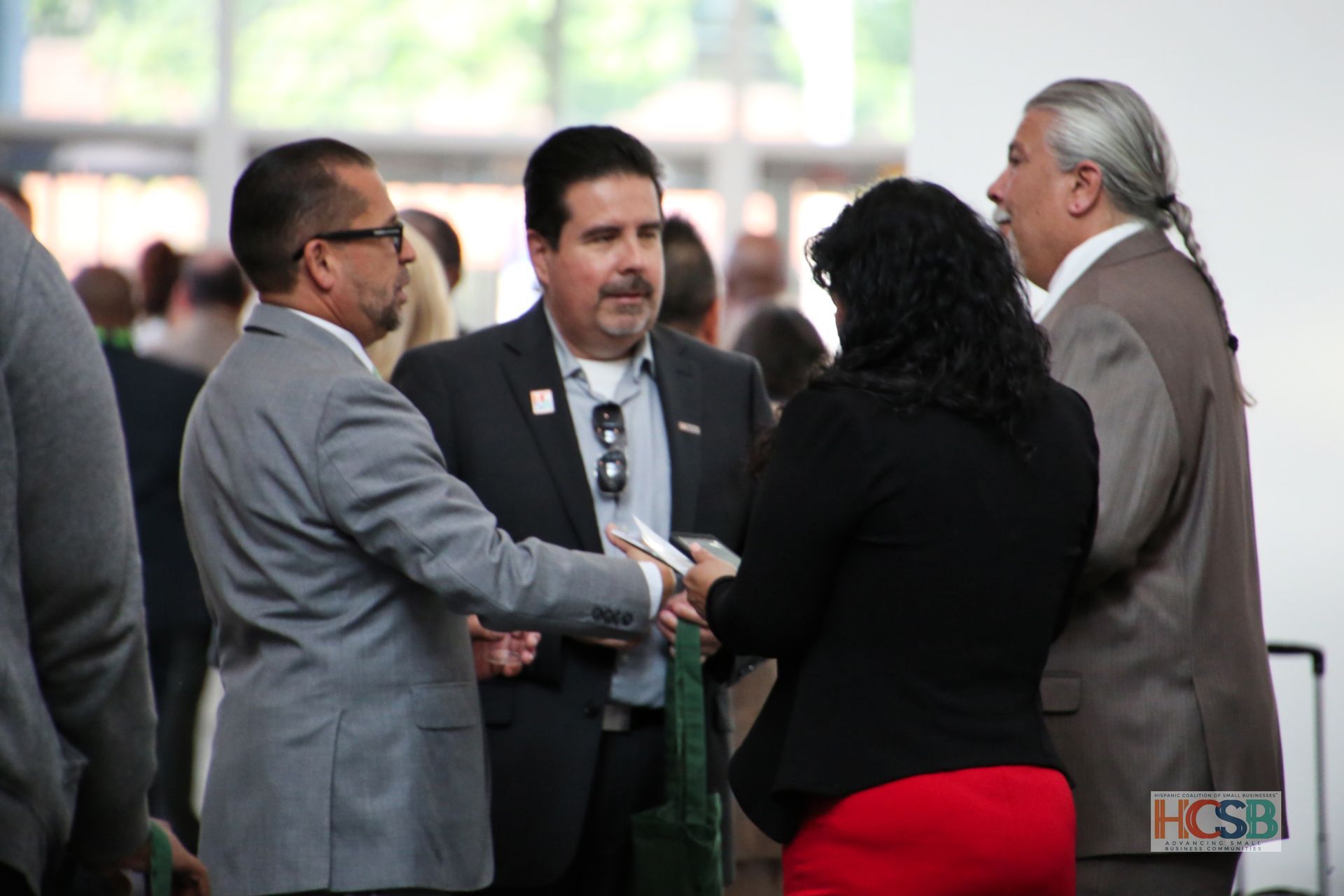 A group of people standing in a room with a hcsb logo in the corner