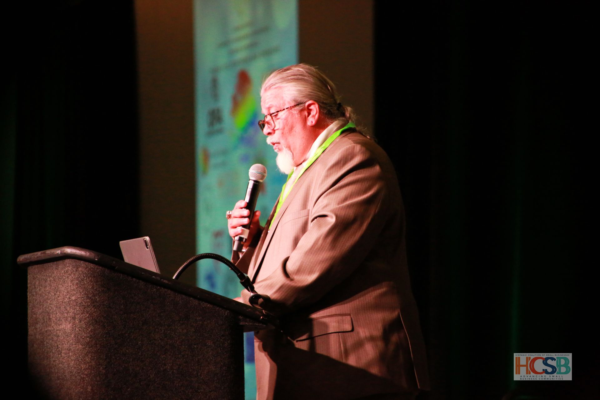 A man stands at a podium with a microphone in his hand