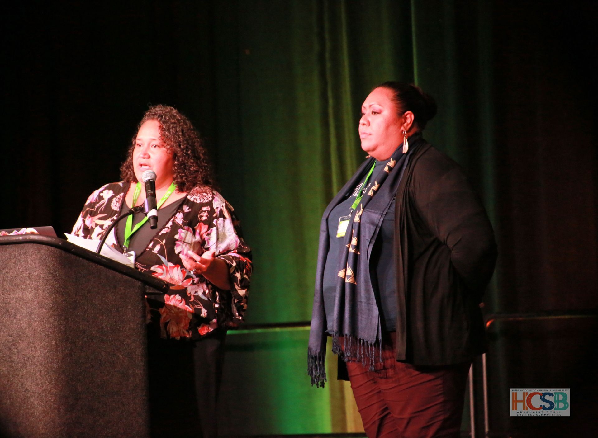Two women are standing at a podium giving a presentation