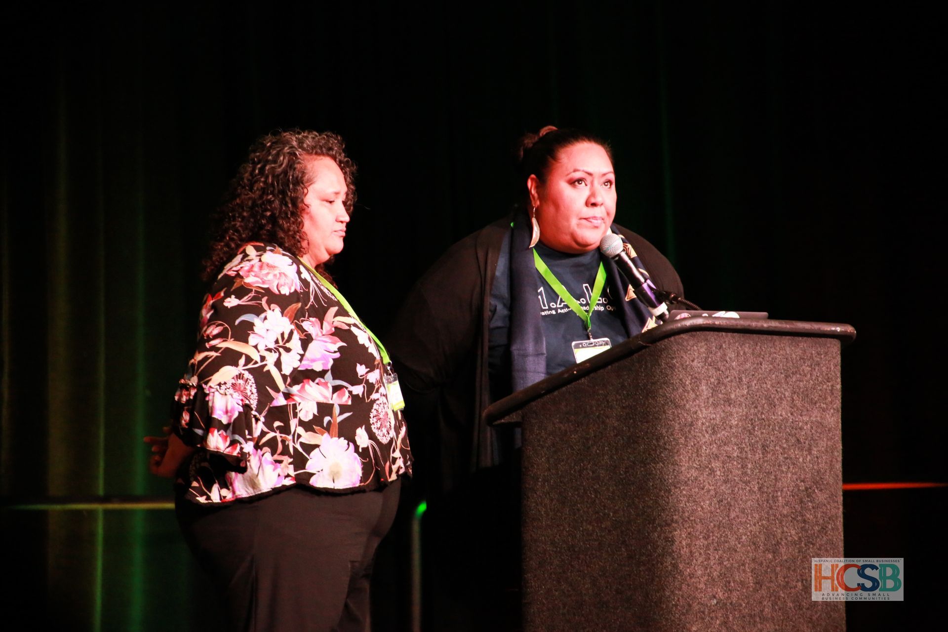 Two women standing next to each other at a podium