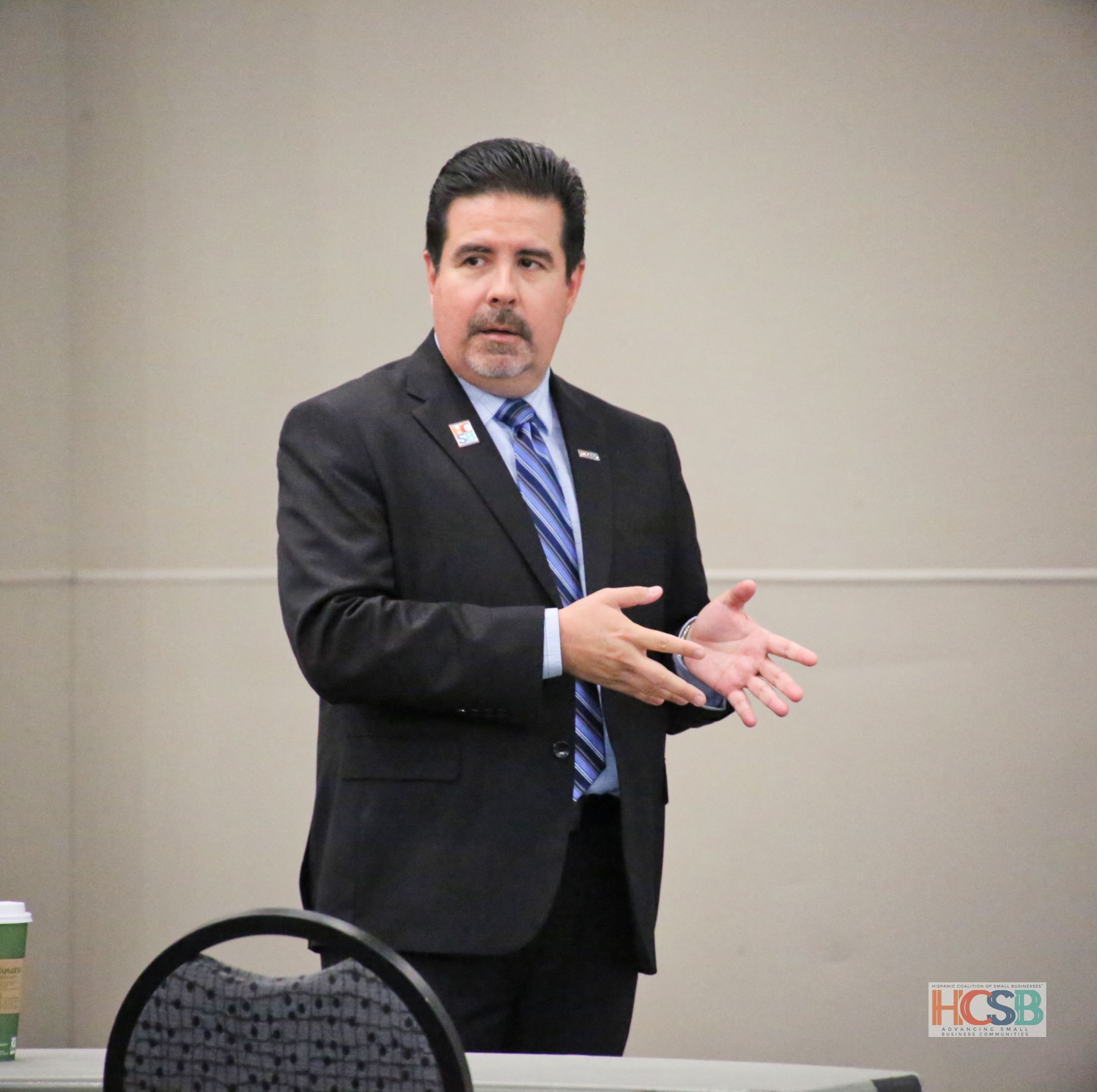 A man in a suit and tie is giving a presentation