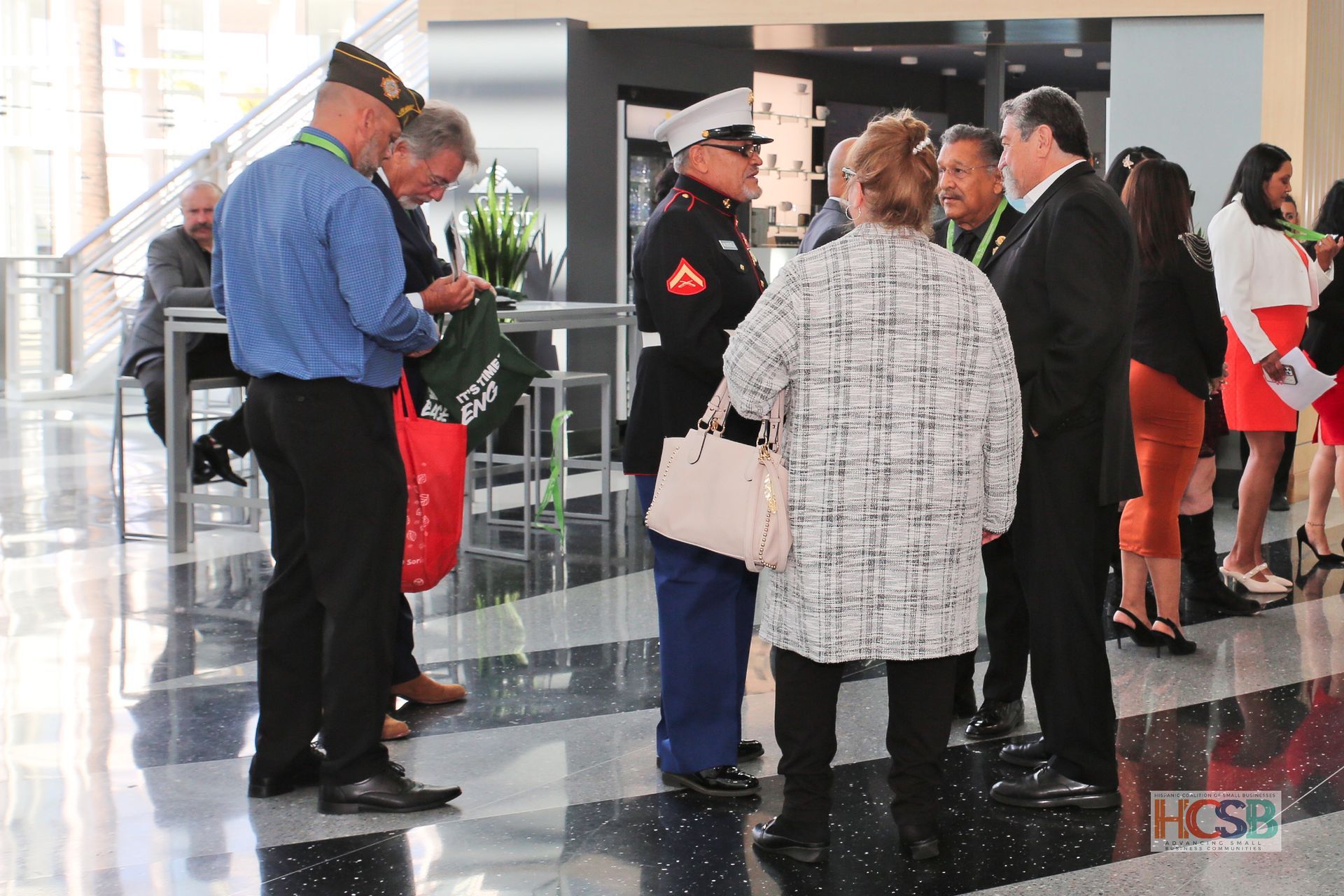 A group of people are standing around a man in a marine uniform