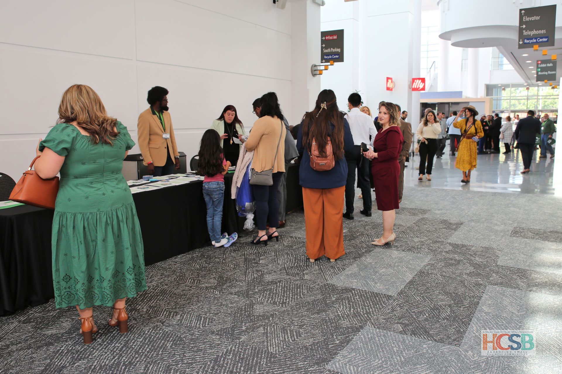A group of people are standing around a table in a hallway.