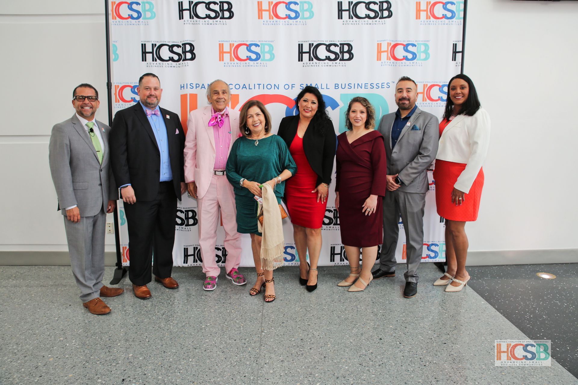 A group of people are posing for a picture in front of a colorful backdrop.