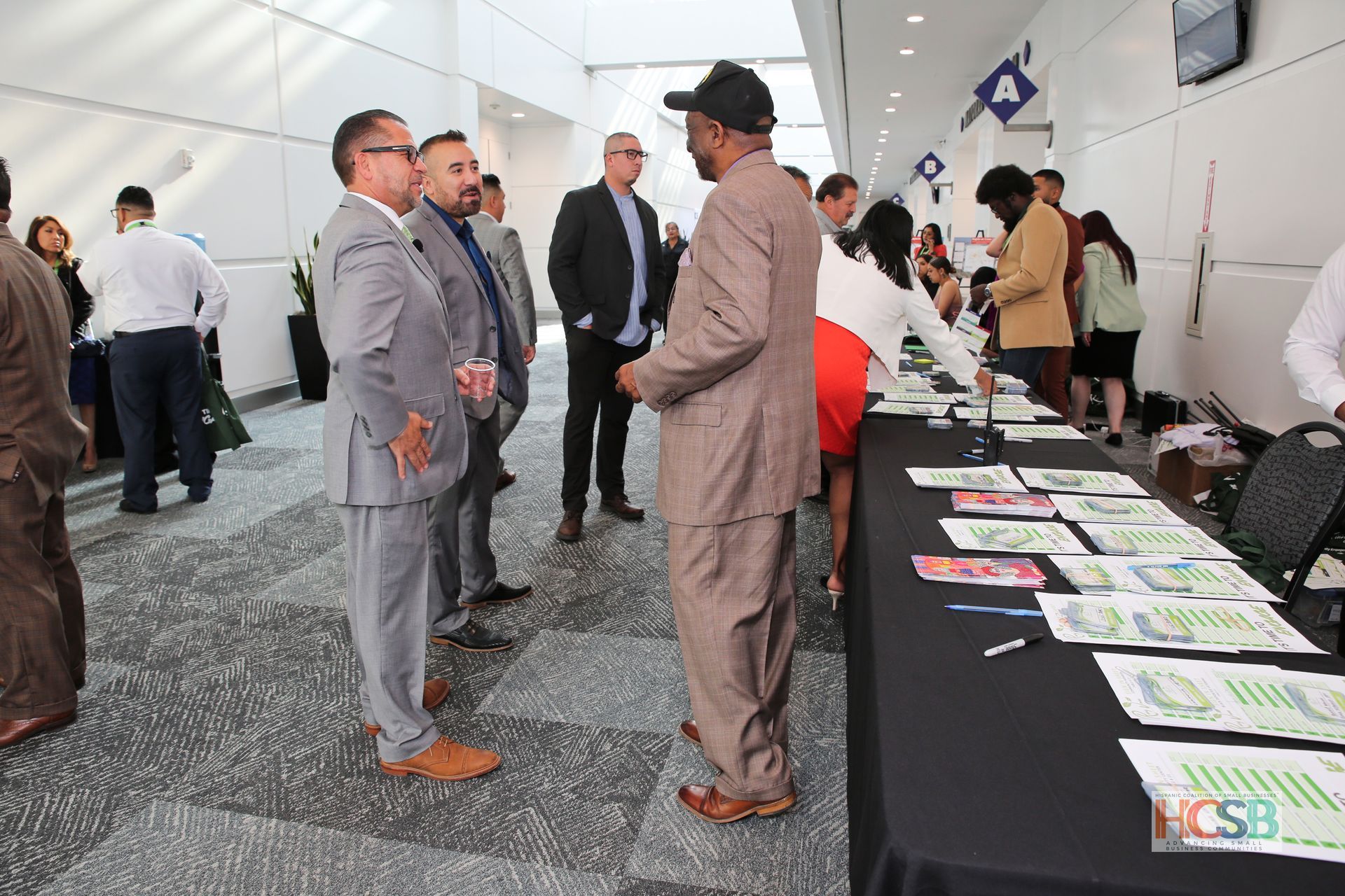 A group of people are standing around a table with papers on it.