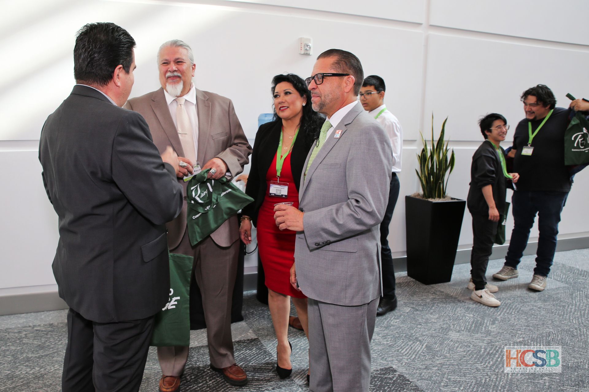A group of people standing in a room with a hcsb logo in the corner