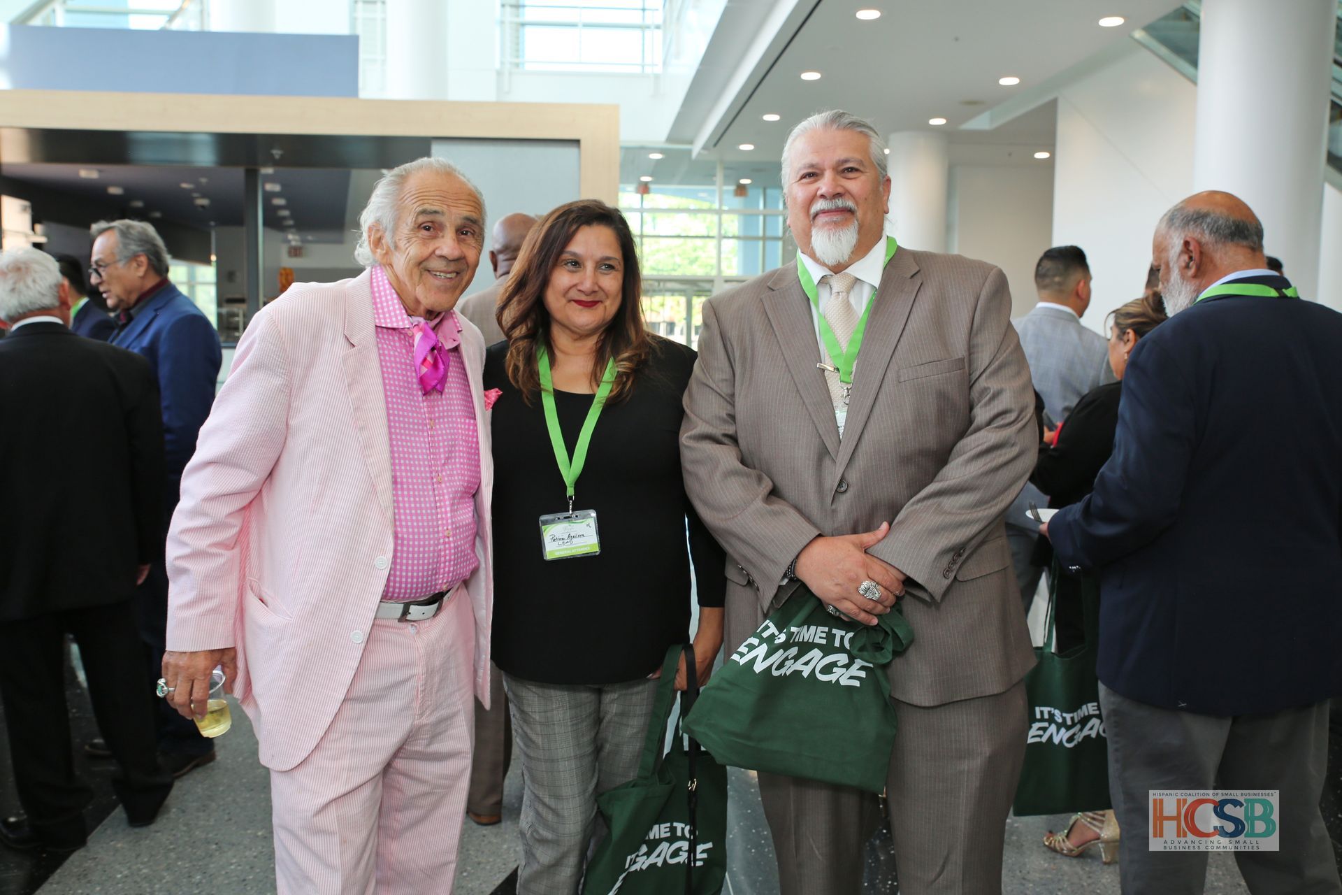 A man in a pink suit is posing for a picture with two other people