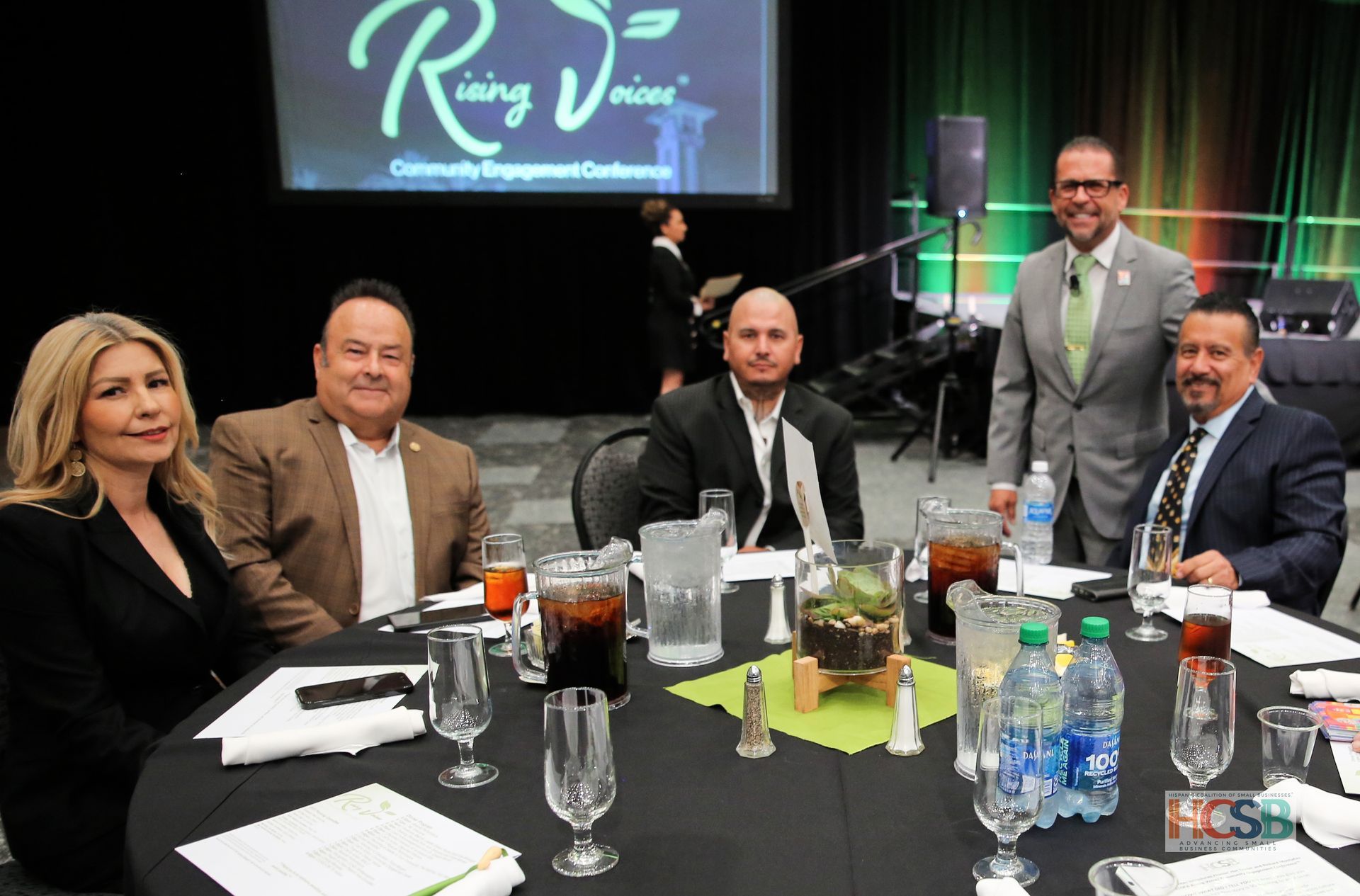 A group of people are sitting at a table with glasses of water.