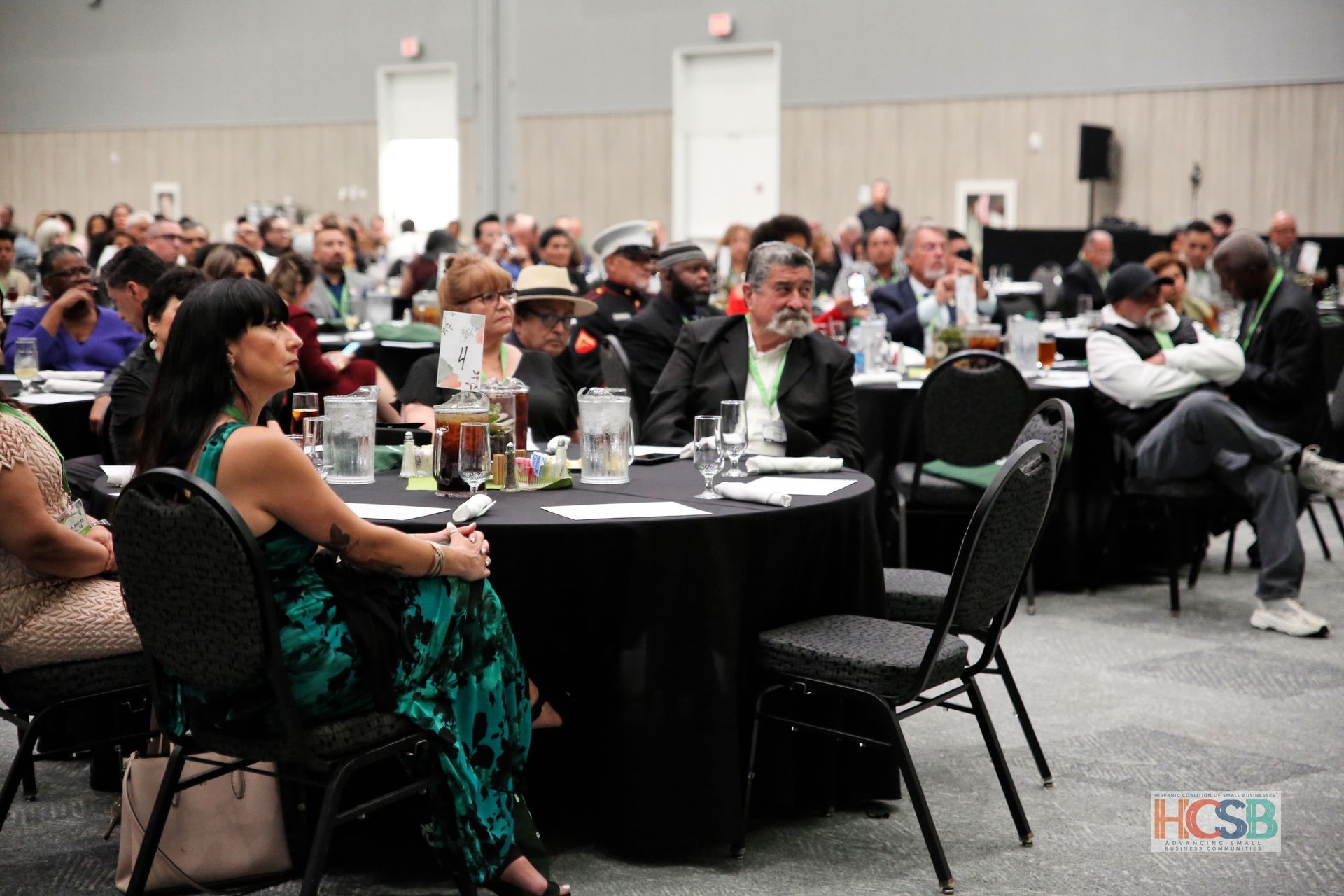 A large group of people are sitting at tables in a conference room.