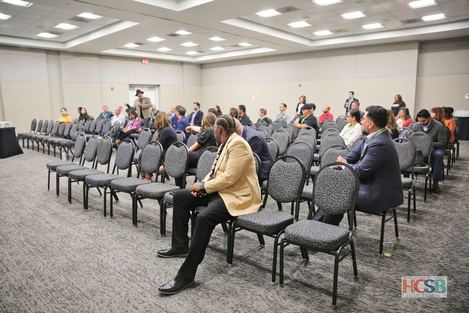 A group of people are sitting in chairs in a conference room.