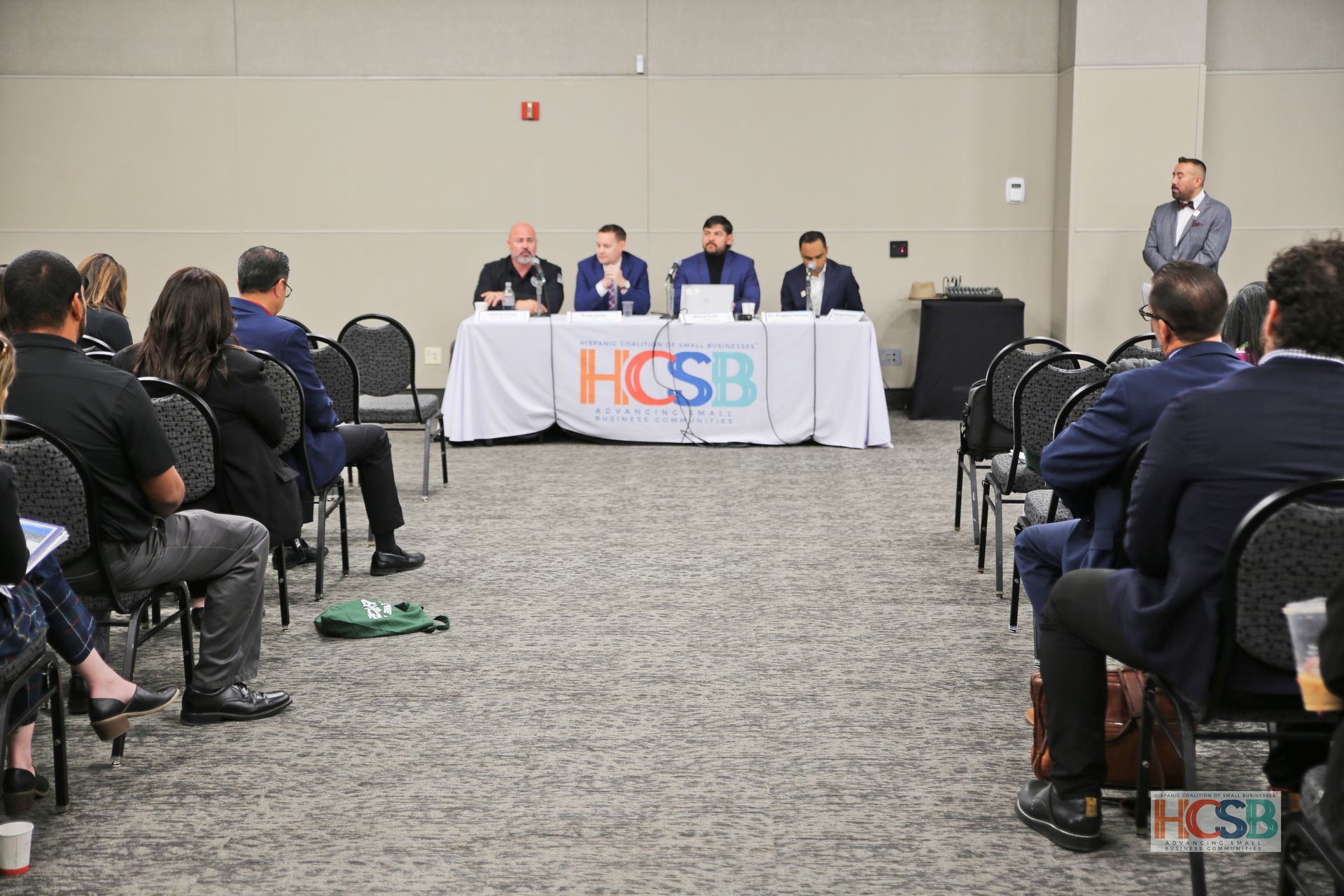 A group of people are sitting at a table in a conference room.