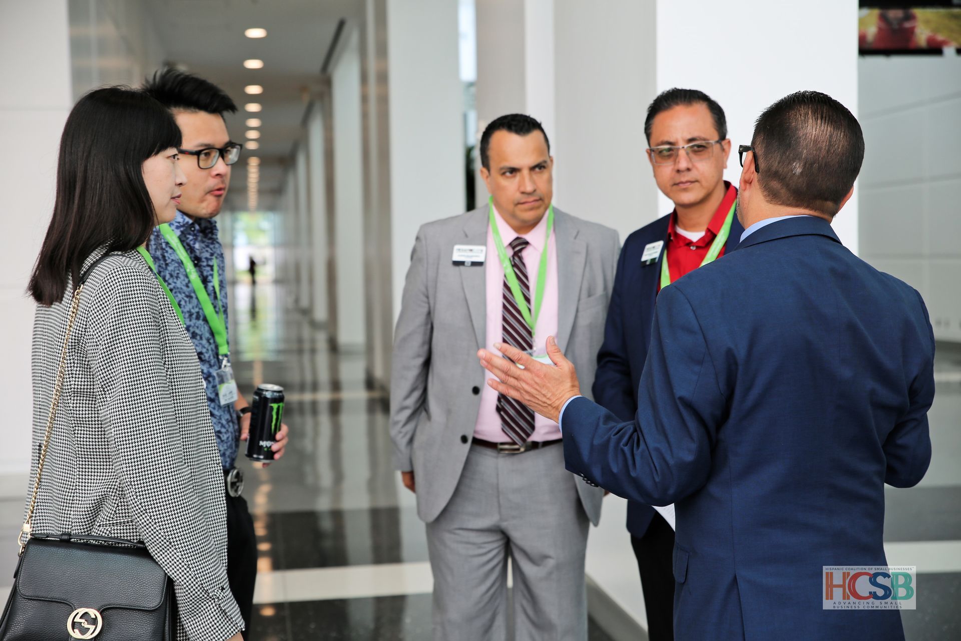 A group of people standing in a hallway with hcsb written on the bottom
