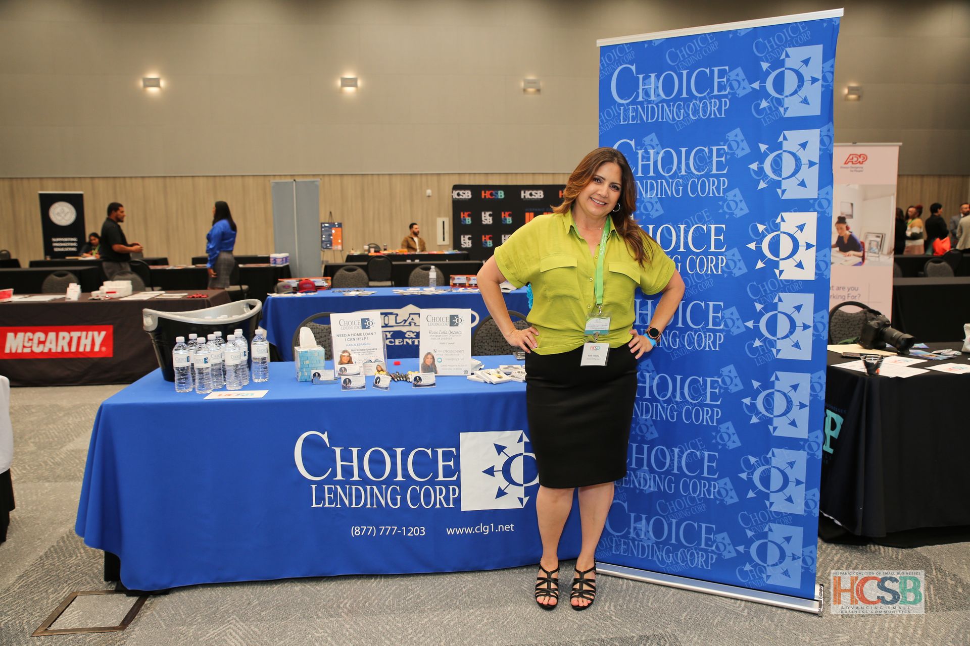 A woman stands in front of a choice lending corp table