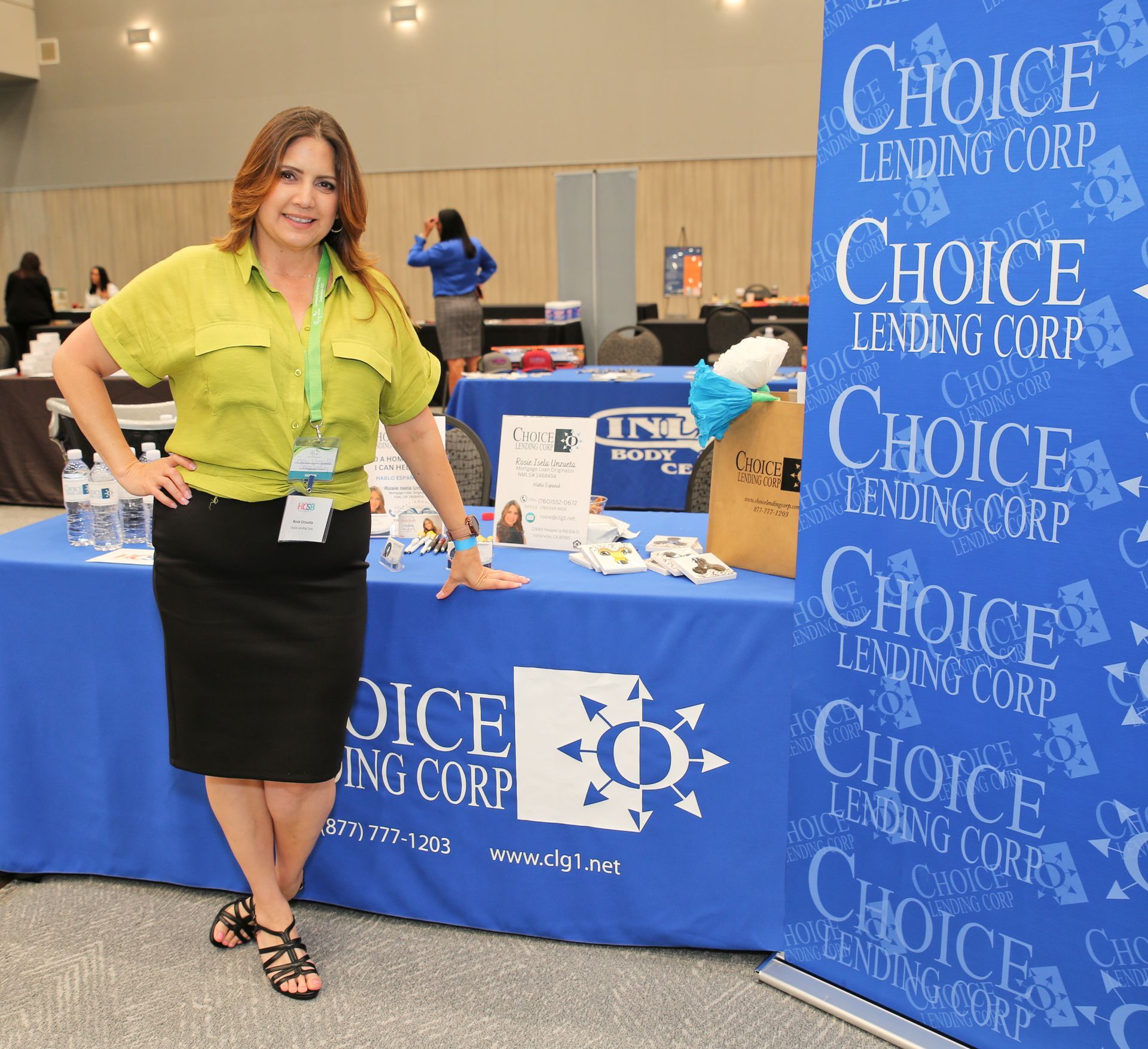 A woman stands in front of a choice lending corp table