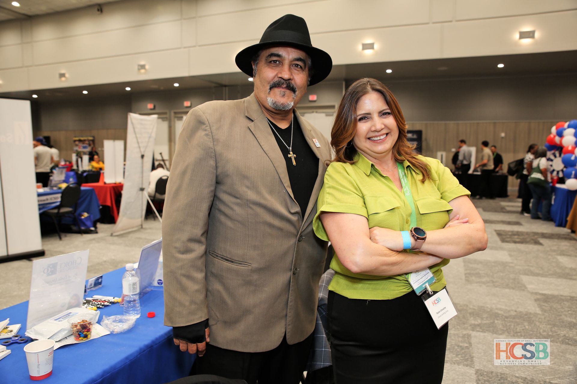 A man and a woman are posing for a picture at a convention.