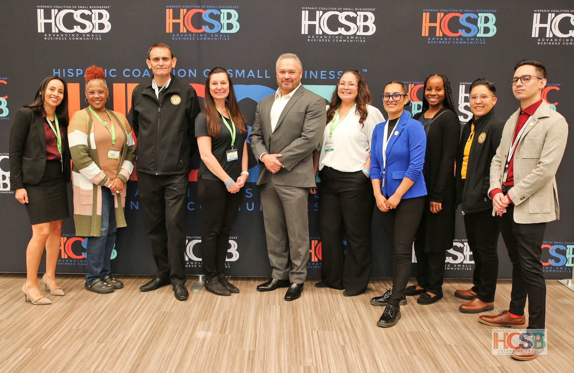 A group of people are posing for a picture in front of a wall.