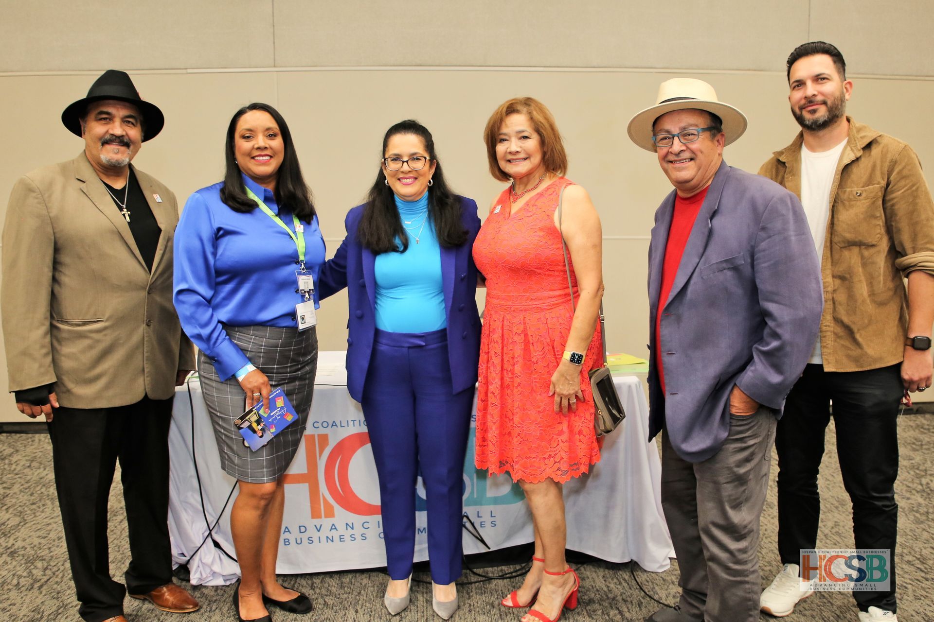 A group of people are posing for a picture in front of a table.