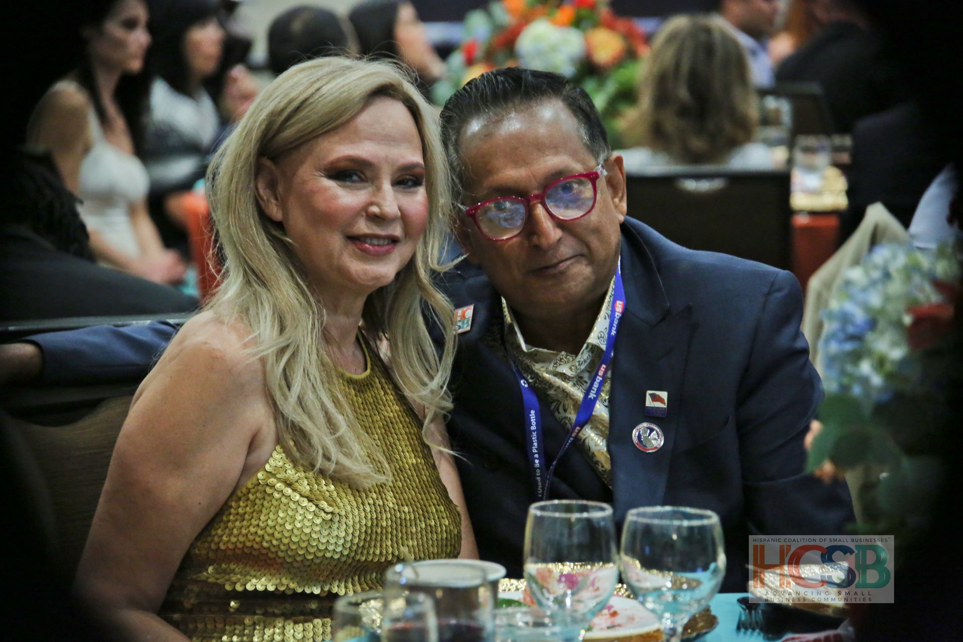 A man and a woman are sitting at a table with wine glasses.
