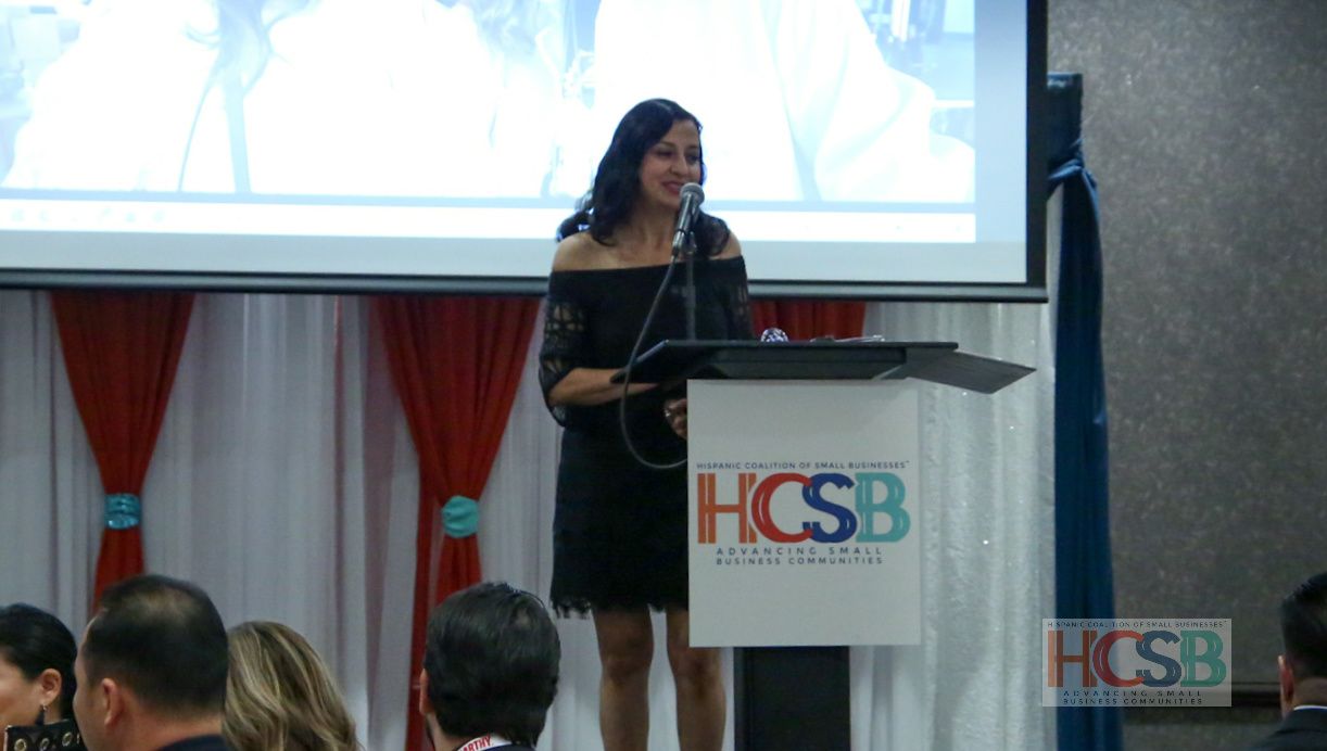 A woman is standing at a podium that says hcsb on it