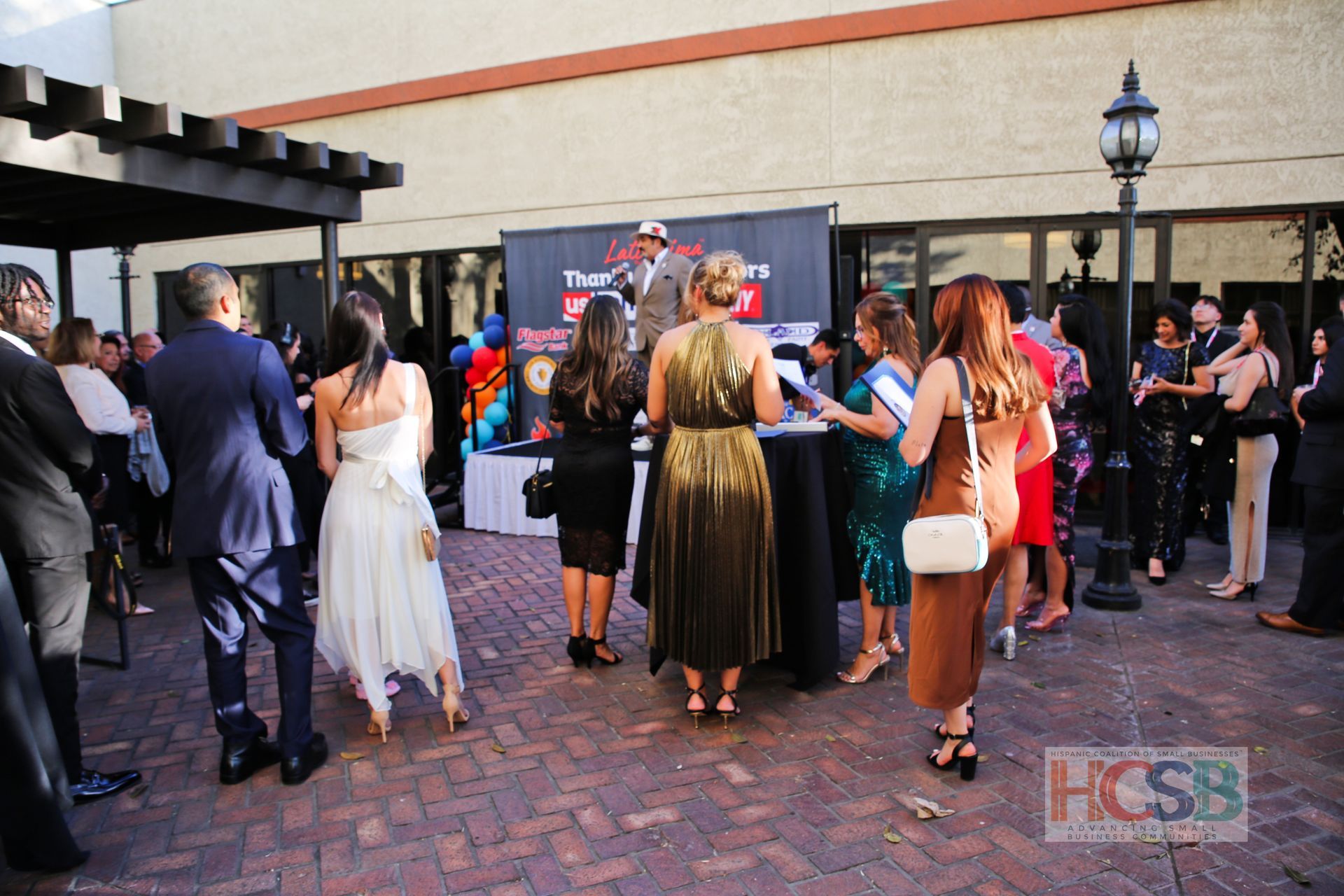 A group of people standing in front of a sign that says hcsb