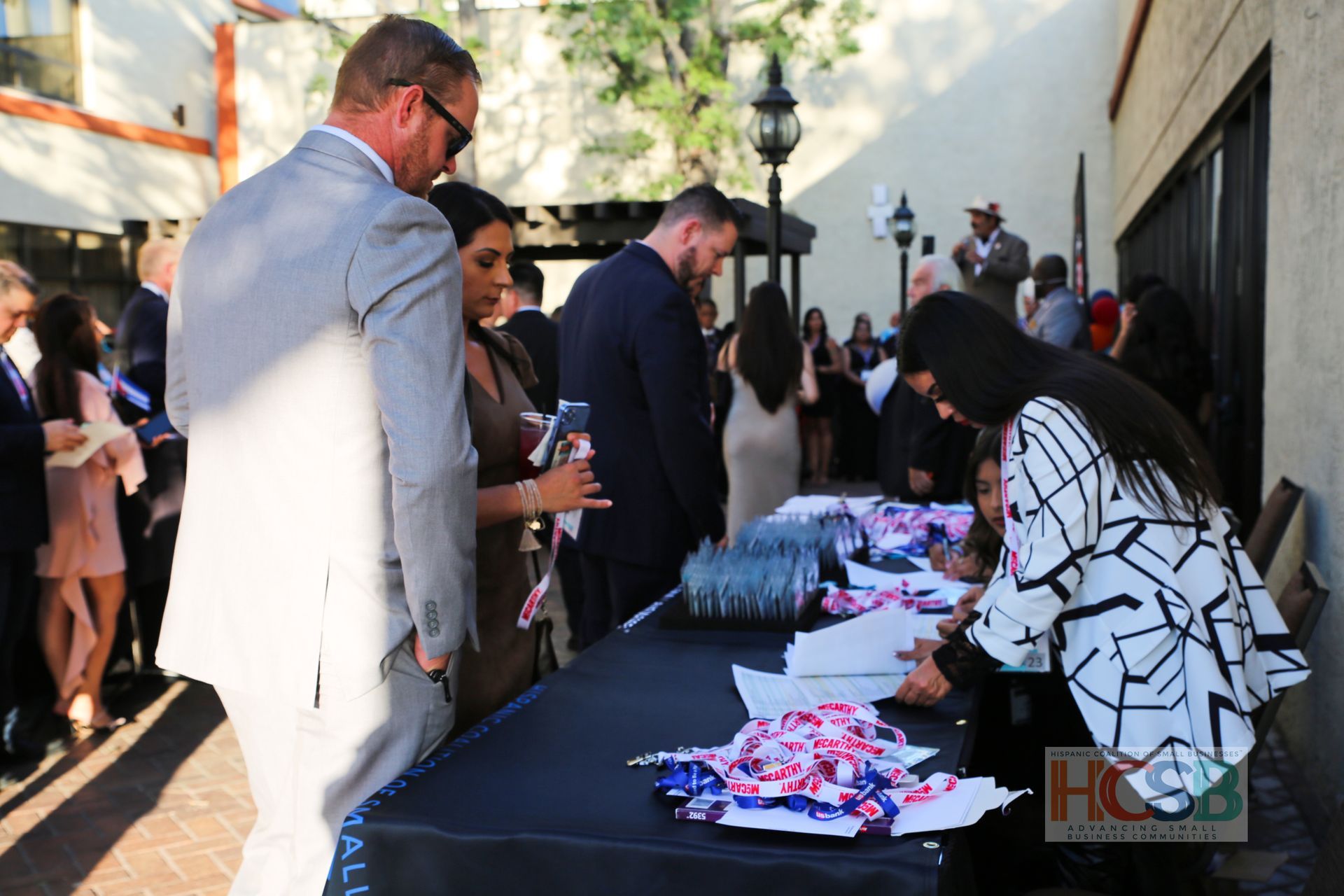 A group of people standing around a table with a sign that says hcsb on it