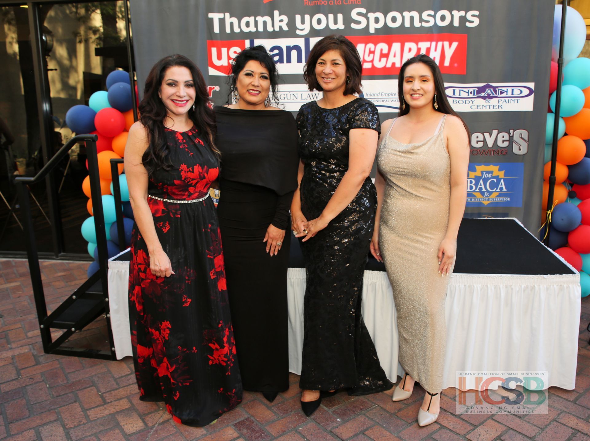 A group of women standing in front of a sign that says thank you sponsors