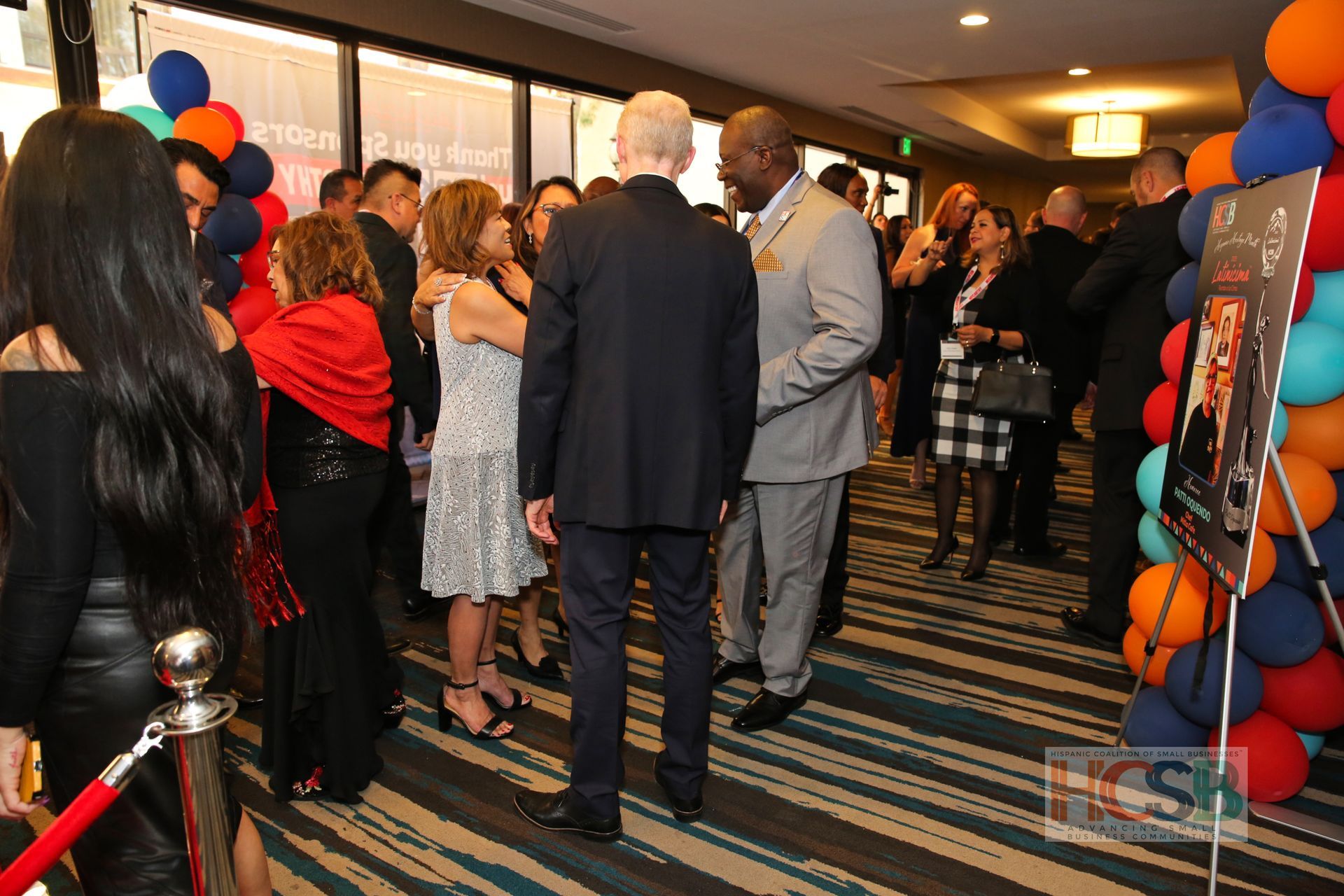 A group of people are standing in a room with balloons.