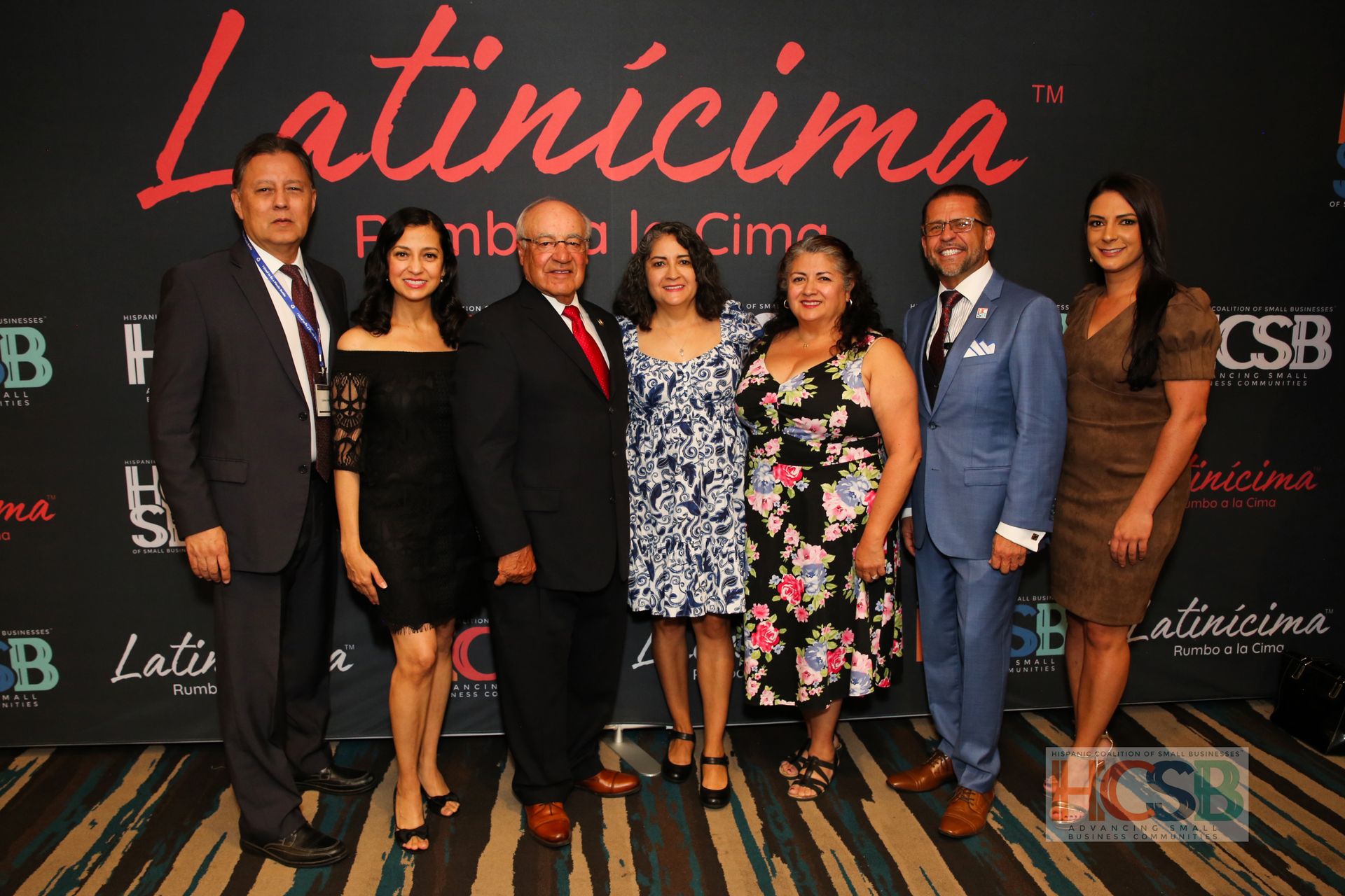 A group of people standing in front of a latincima sign