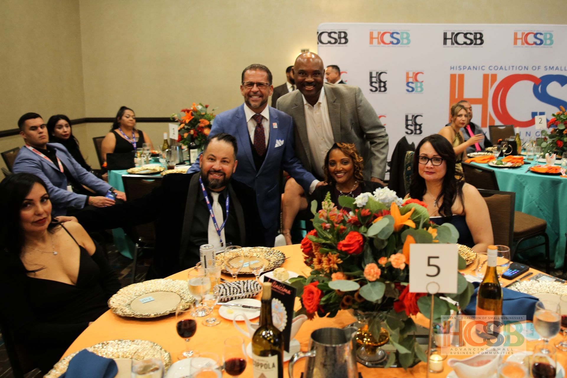 A group of people are posing for a picture at a dinner table.